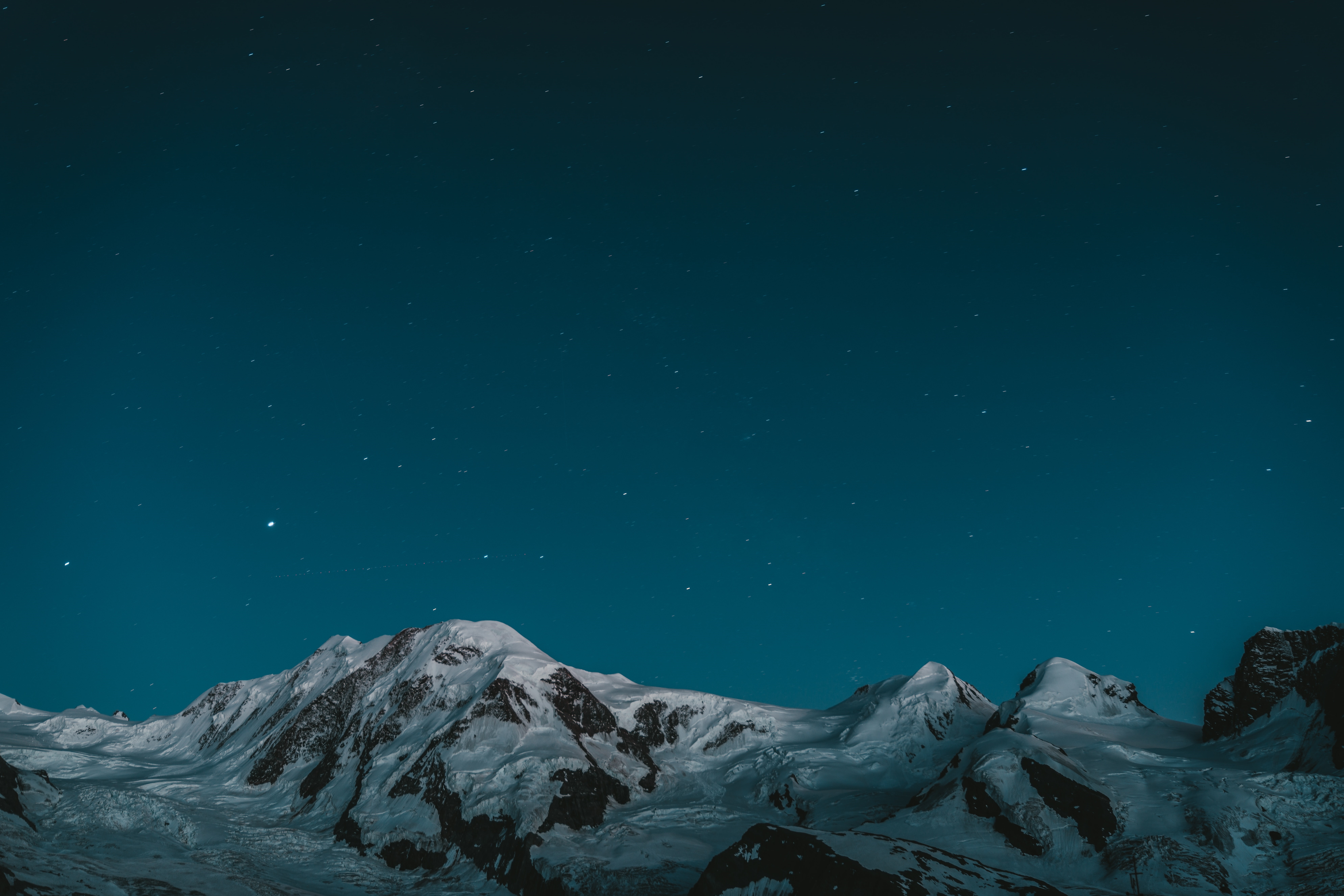 Snowy mountains under a starry night sky HD Wallpaper