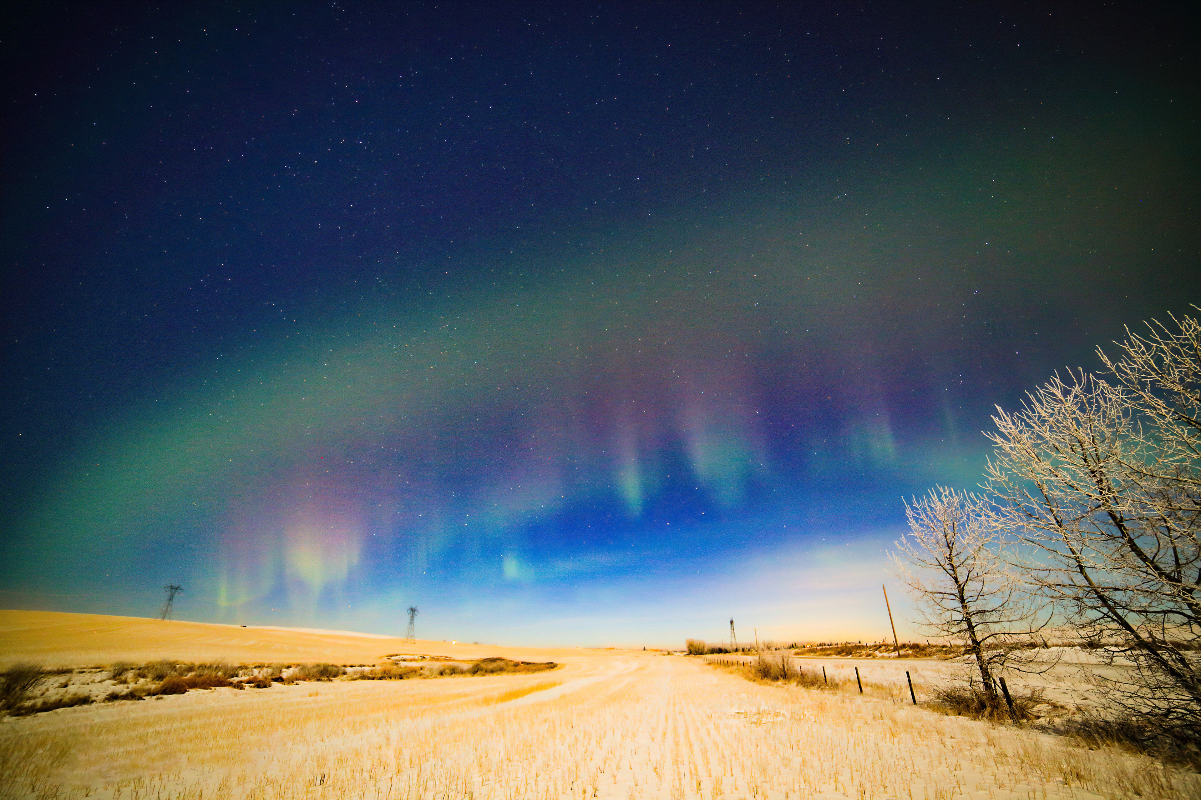 Aurora Borealis over a snowy field at night HD Wallpaper