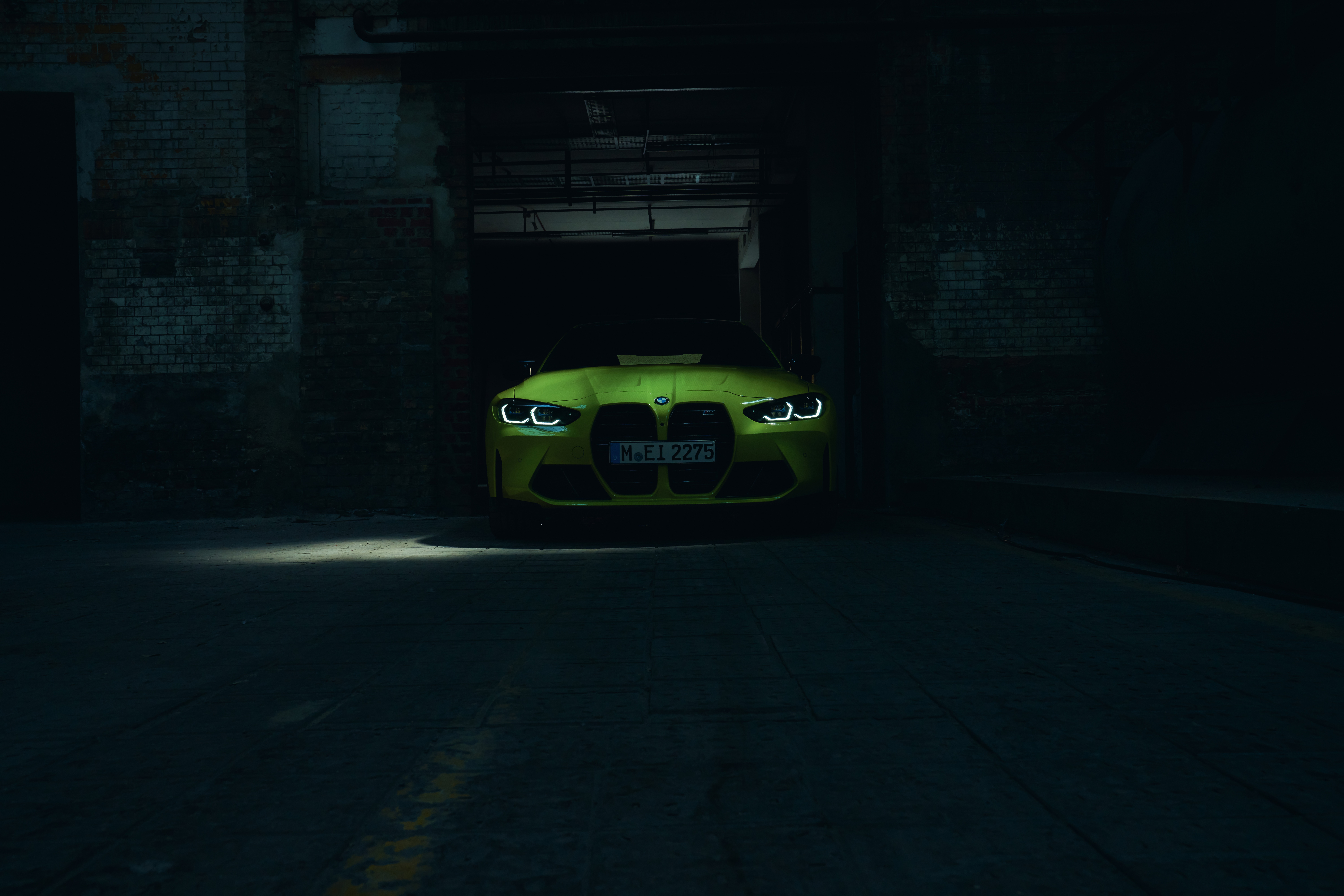 Yellow BMW M4 parked in a dark garage HD Wallpaper