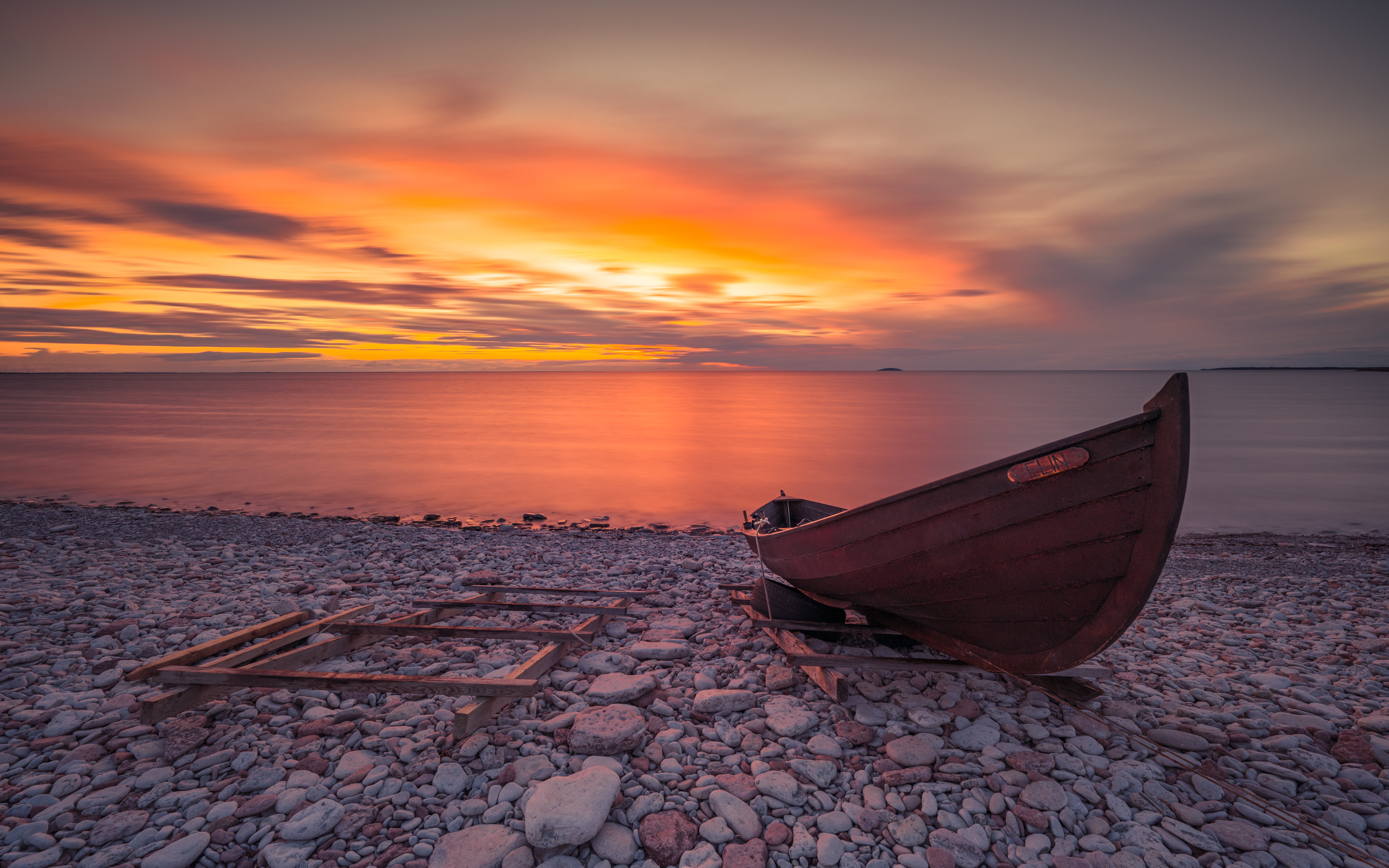 Boat on a rocky shore at sunset HD Wallpaper