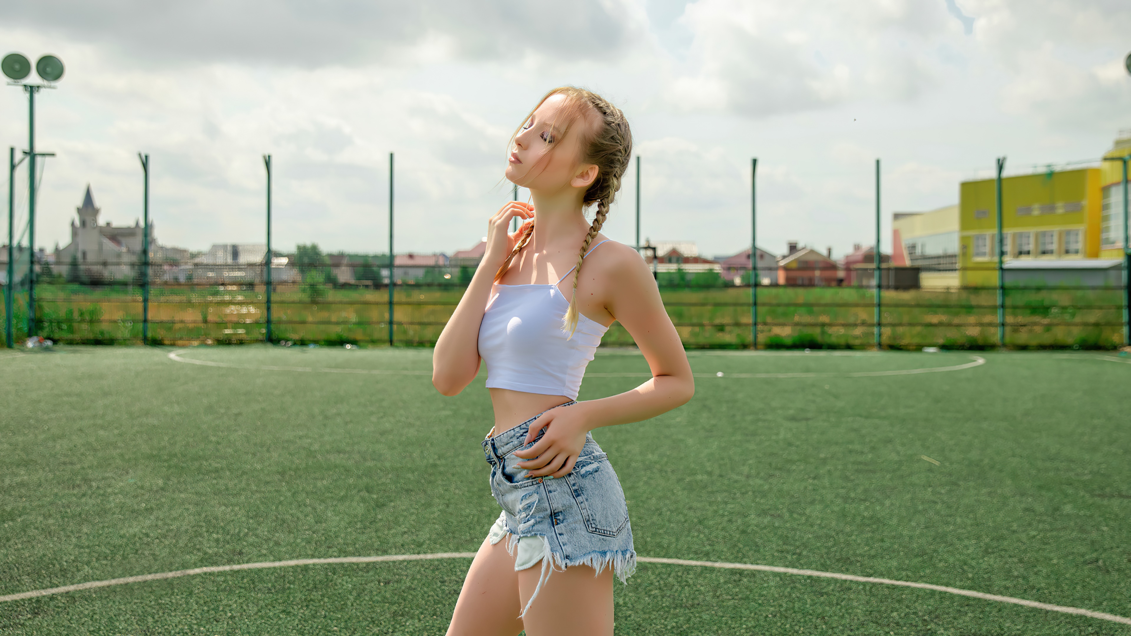 Girl in white top and denim shorts on sports field HD Wallpaper