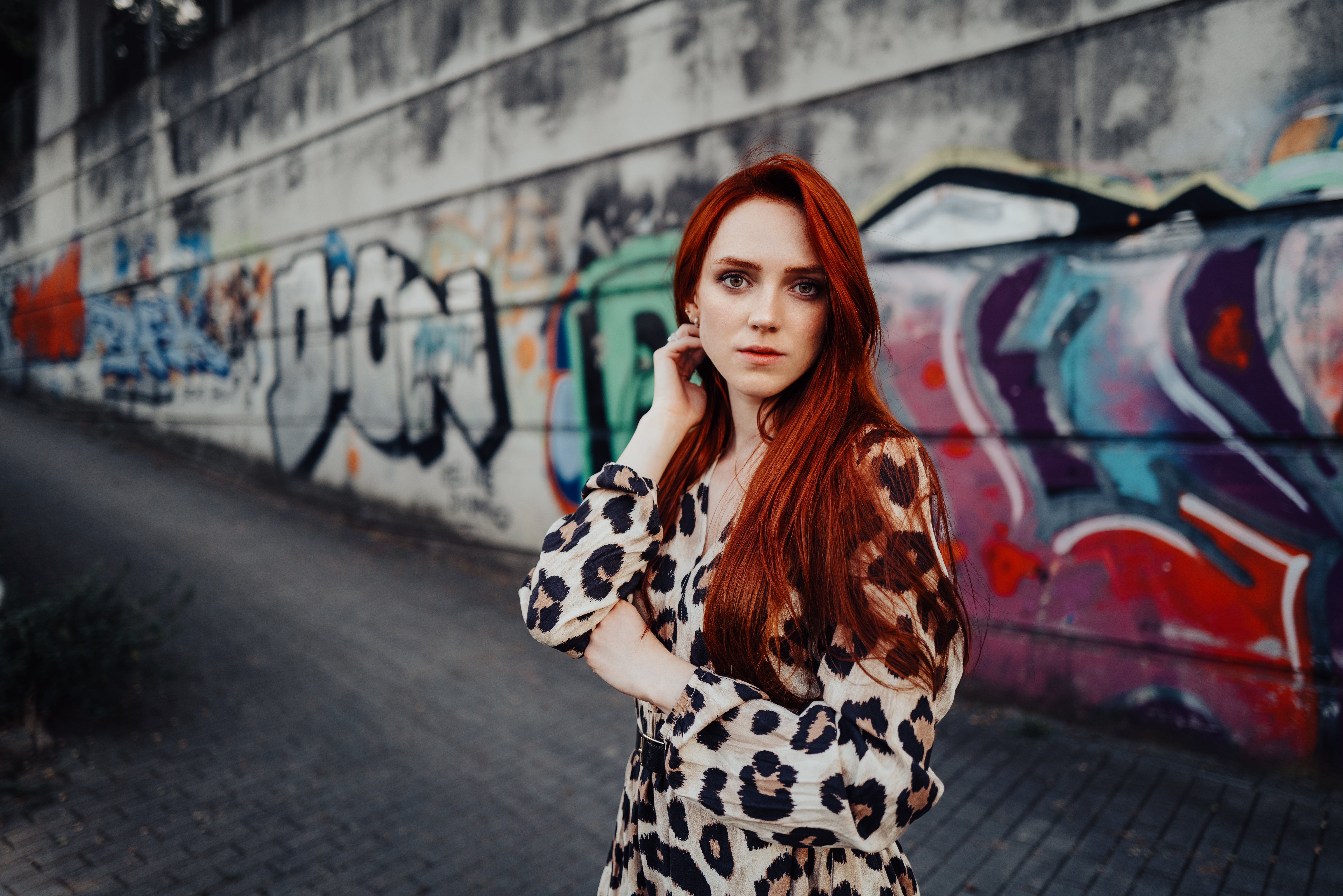 Redhead woman in leopard print dress in front of graffiti wall HD Wallpaper