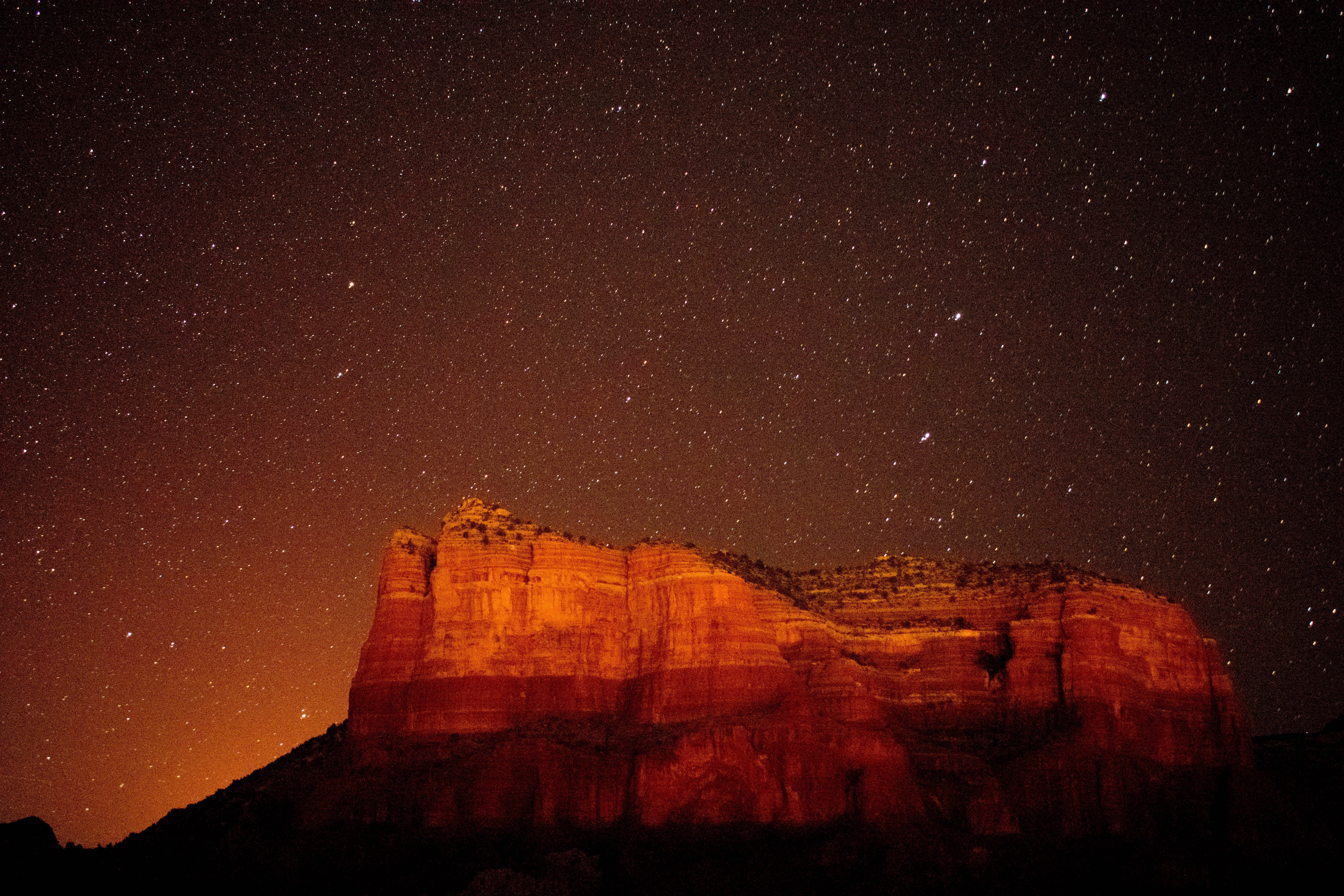 Red rock formations under a starry night sky HD Wallpaper