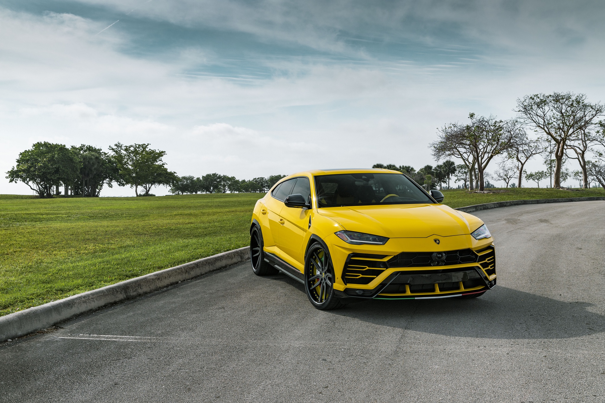 Yellow Lamborghini Urus SUV on a scenic road HD Wallpaper