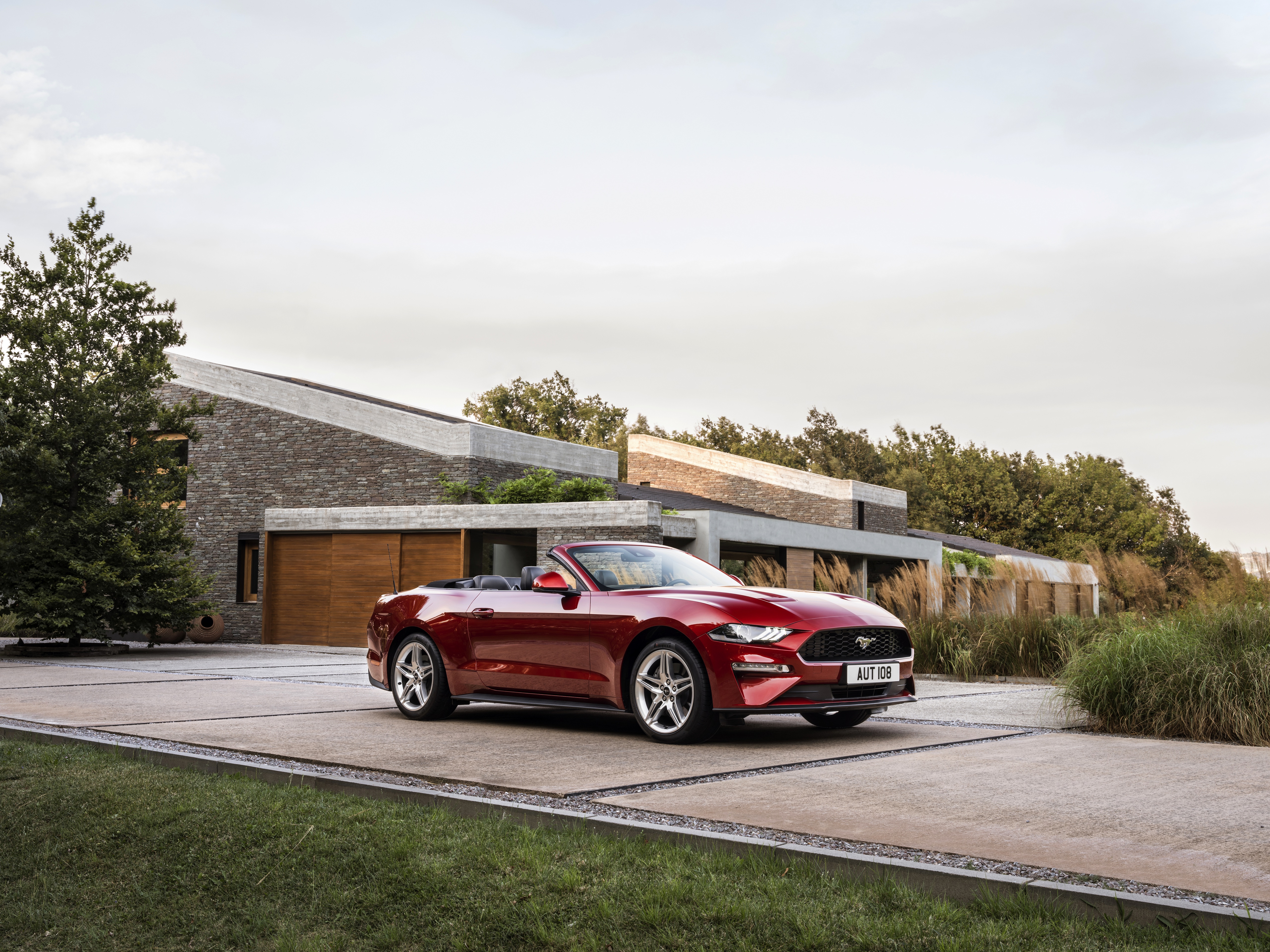Red Ford Mustang Cabriolet in front of modern house 4K HD Wallpaper