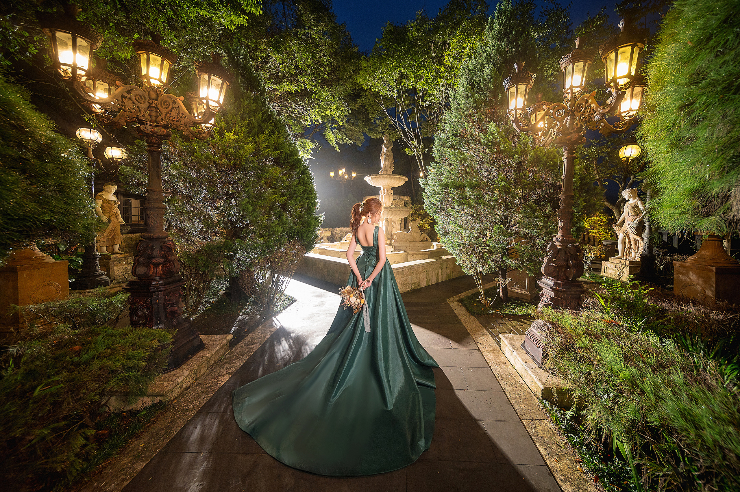 Asian model in green dress in illuminated garden HD Wallpaper