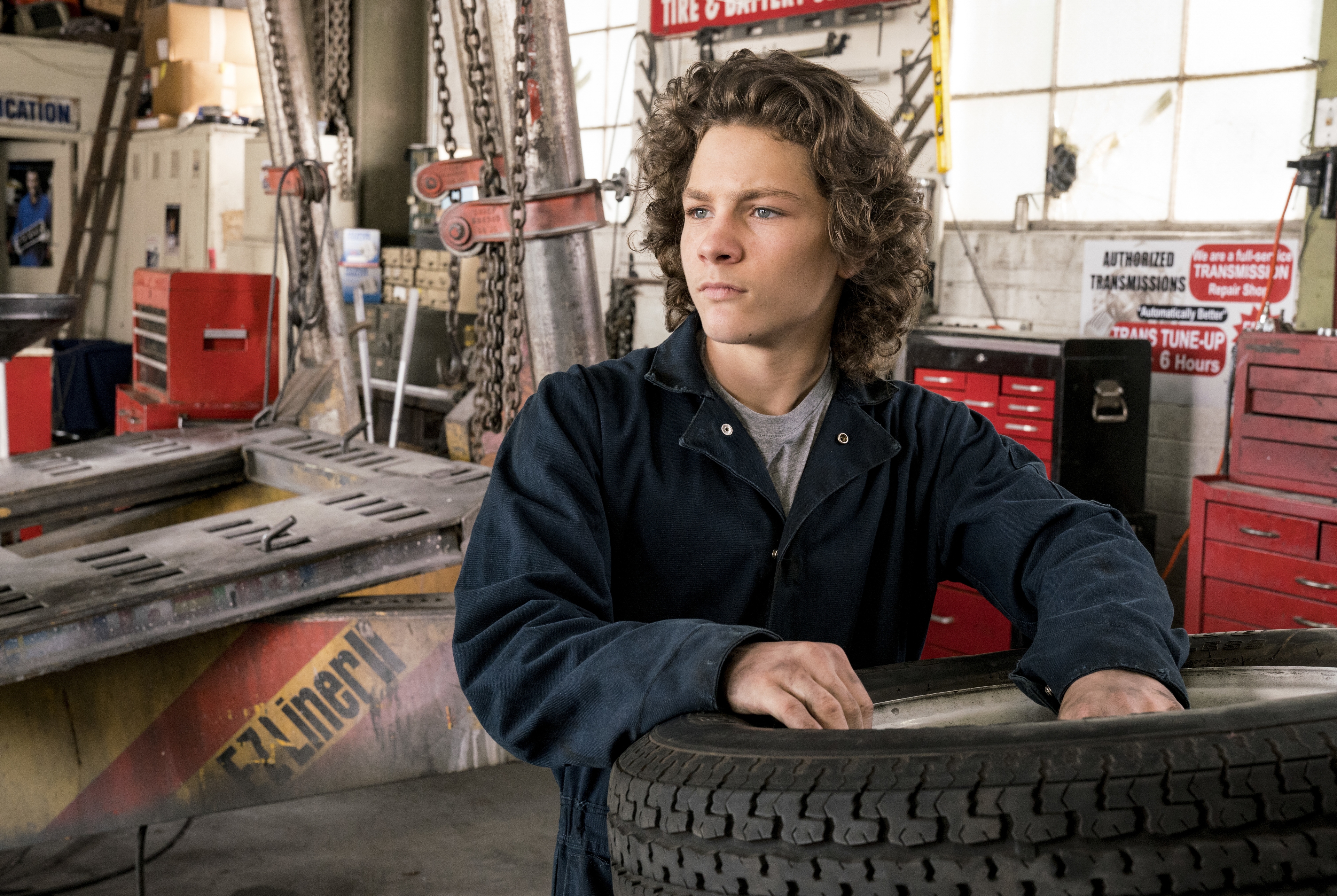 George Cooper Jr. in mechanic shop with tire HD Wallpaper