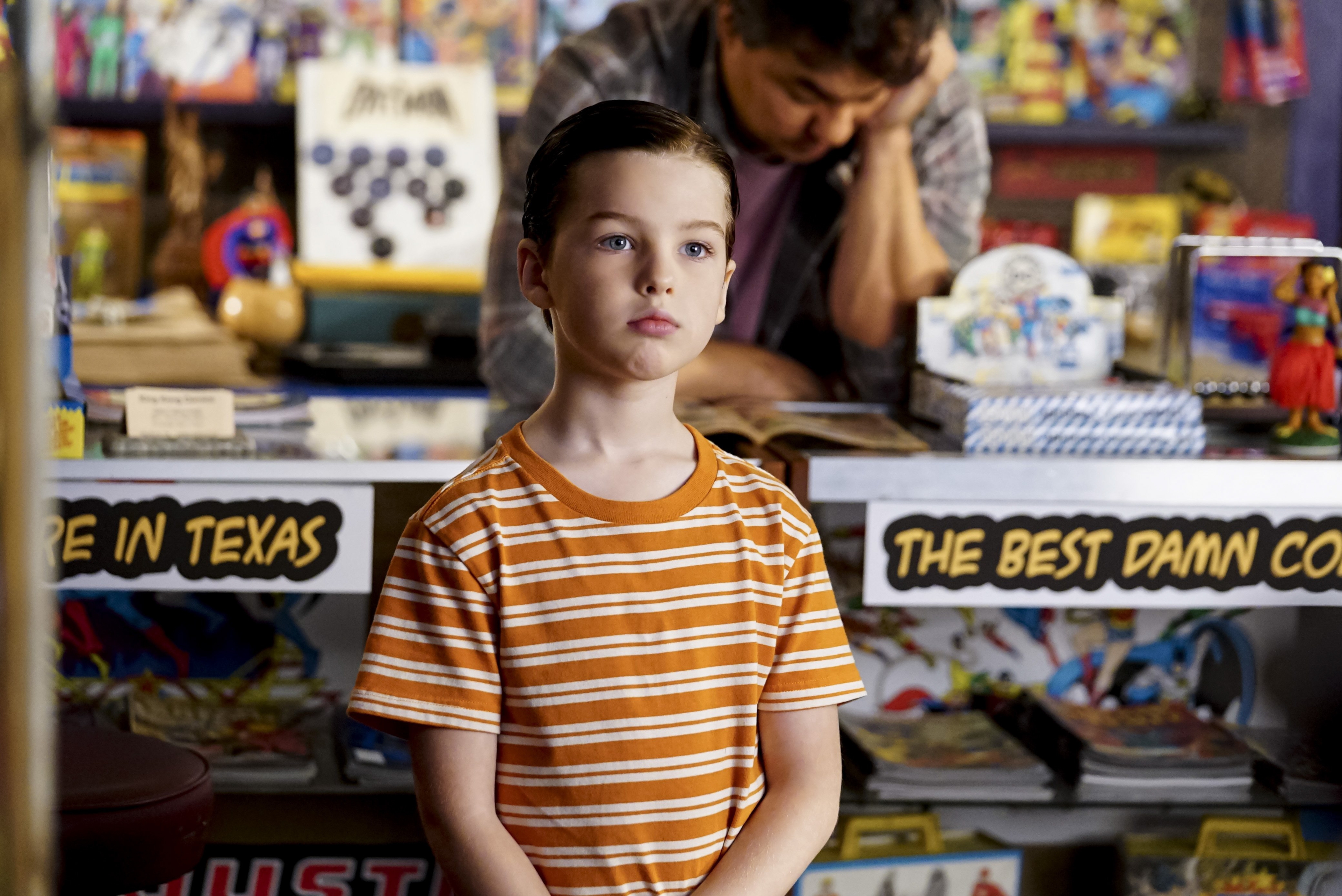 Young Sheldon looking thoughtful in comic shop HD Wallpaper