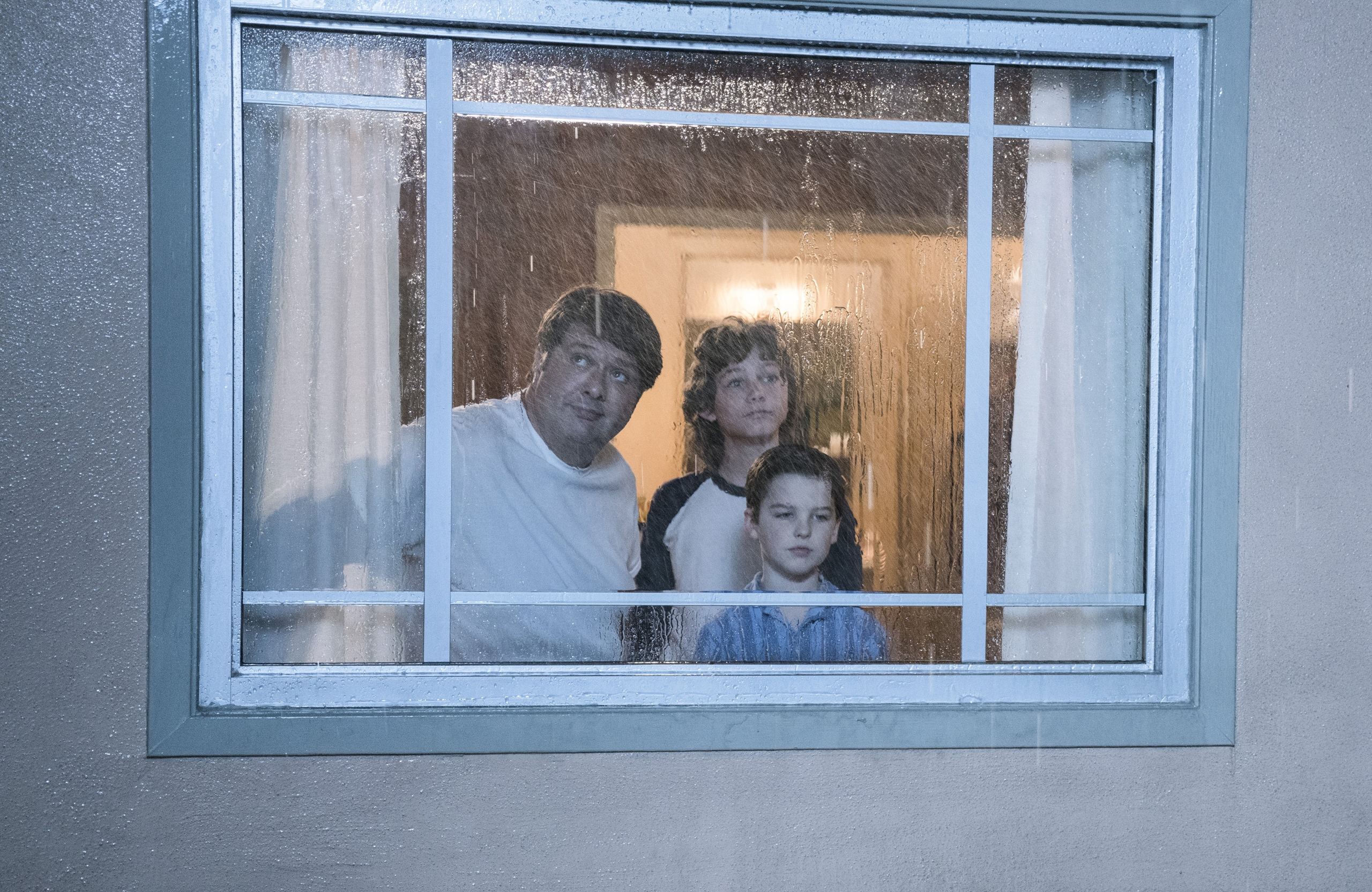 Young Sheldon: George, Sheldon, George Jr. look out rainy window HD Wallpaper