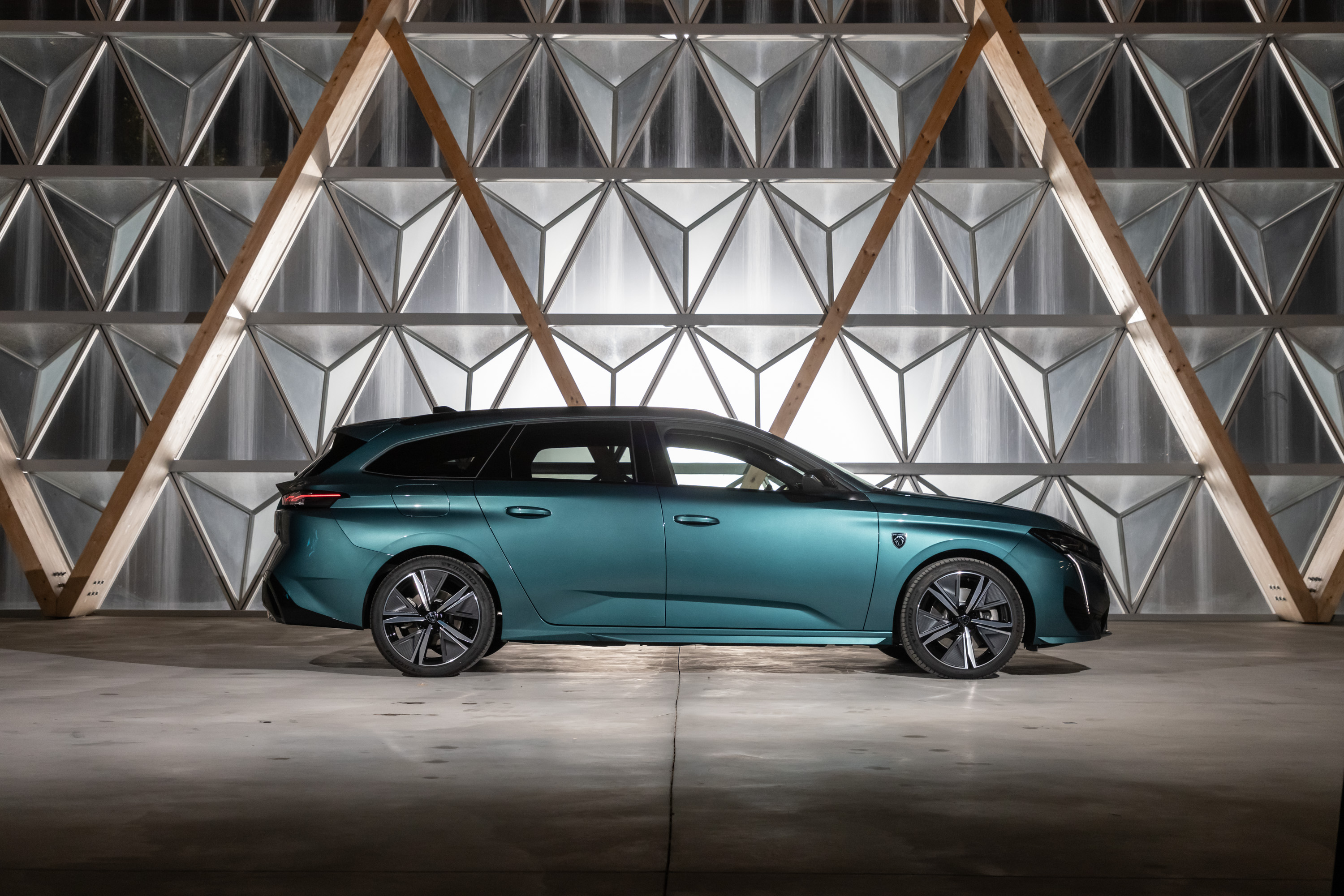 Teal Peugeot 308 SW Hybrid against geometric wall HD Wallpaper
