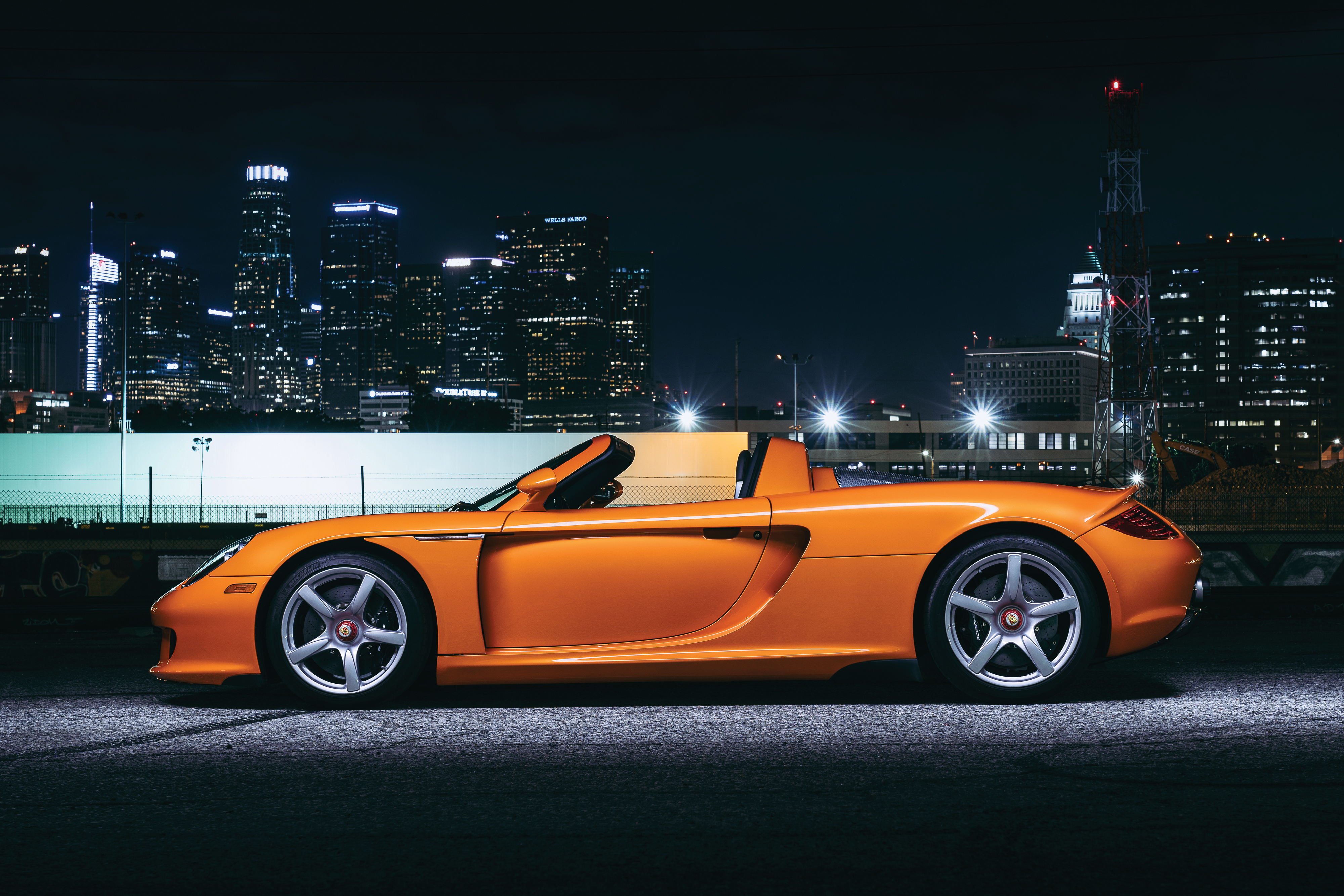 Orange Porsche Carrera GT 4K against City Skyline HD Wallpaper