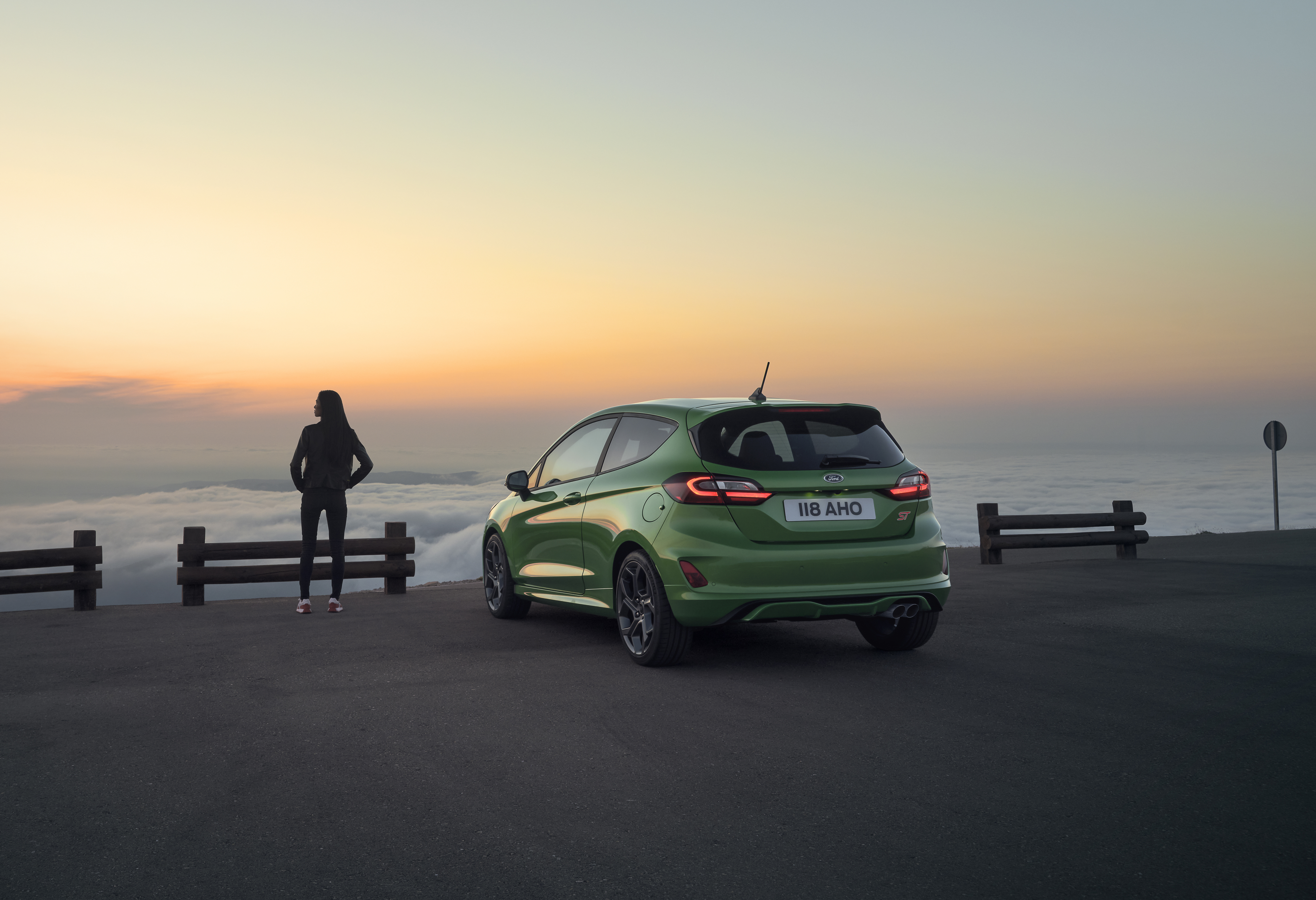 Green Ford Fiesta ST and woman at sunset overlook HD Wallpaper