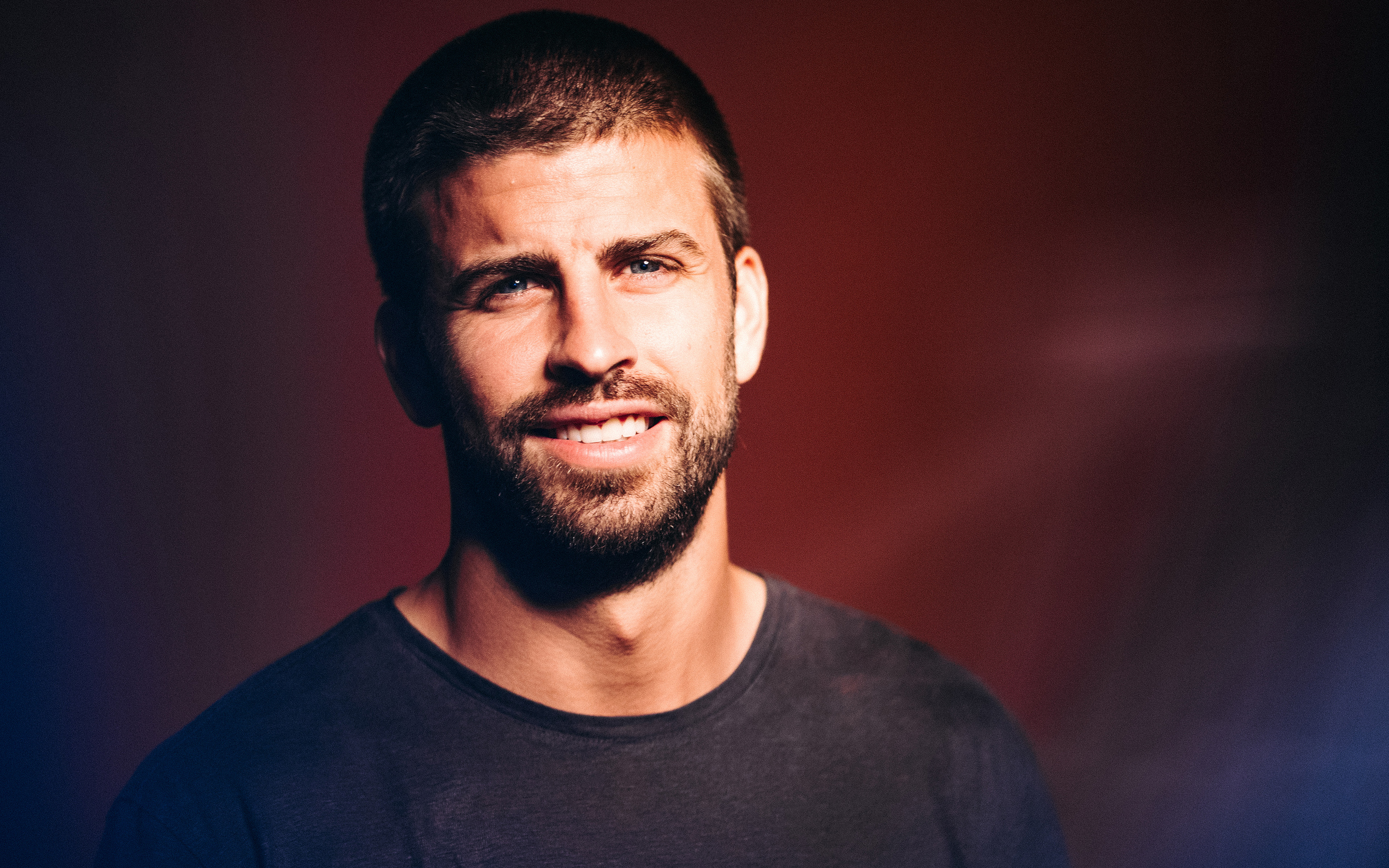 Gerard Piqué smiling portrait with red and blue lighting HD Wallpaper