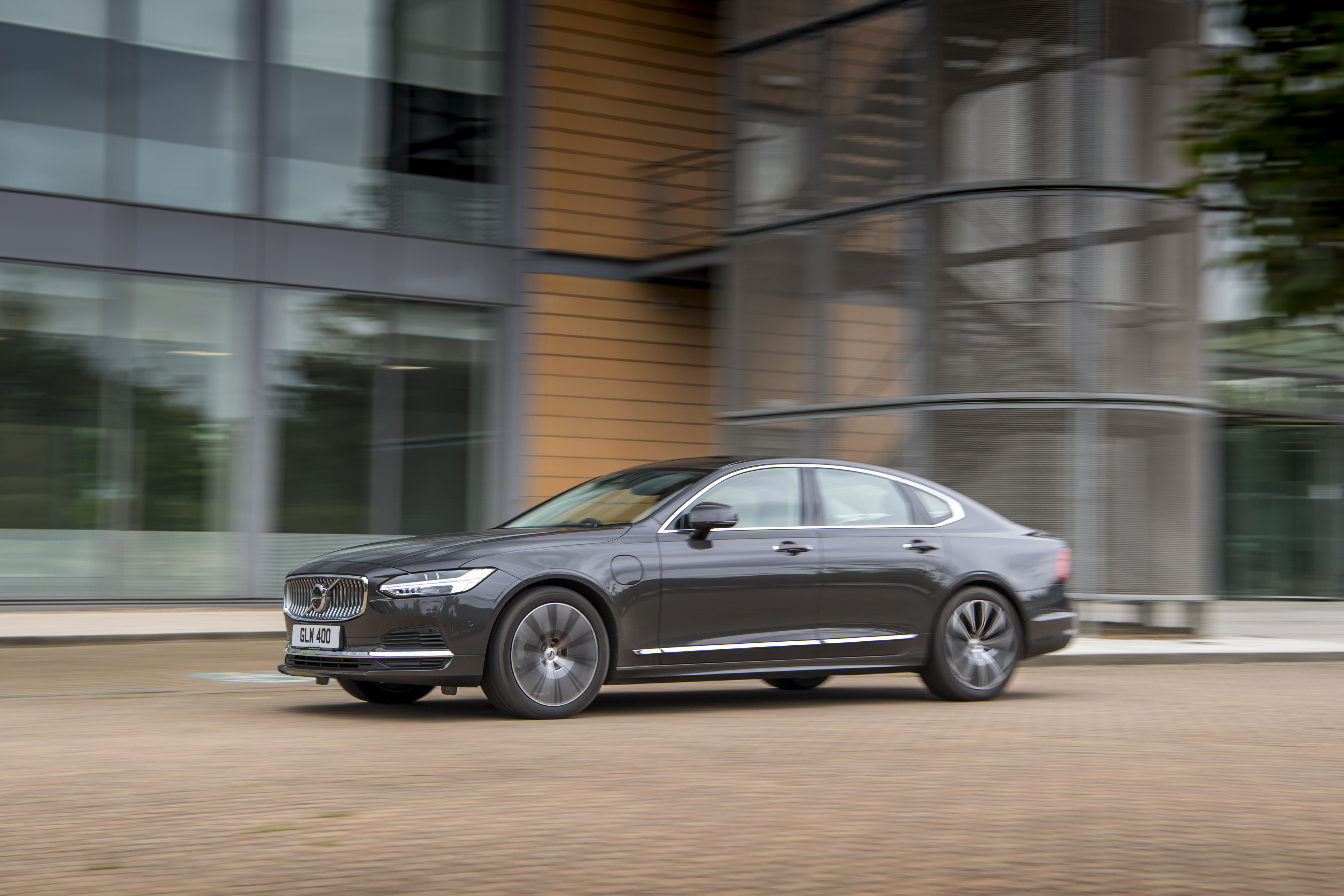 Volvo S90 luxury car driving by modern building HD Wallpaper