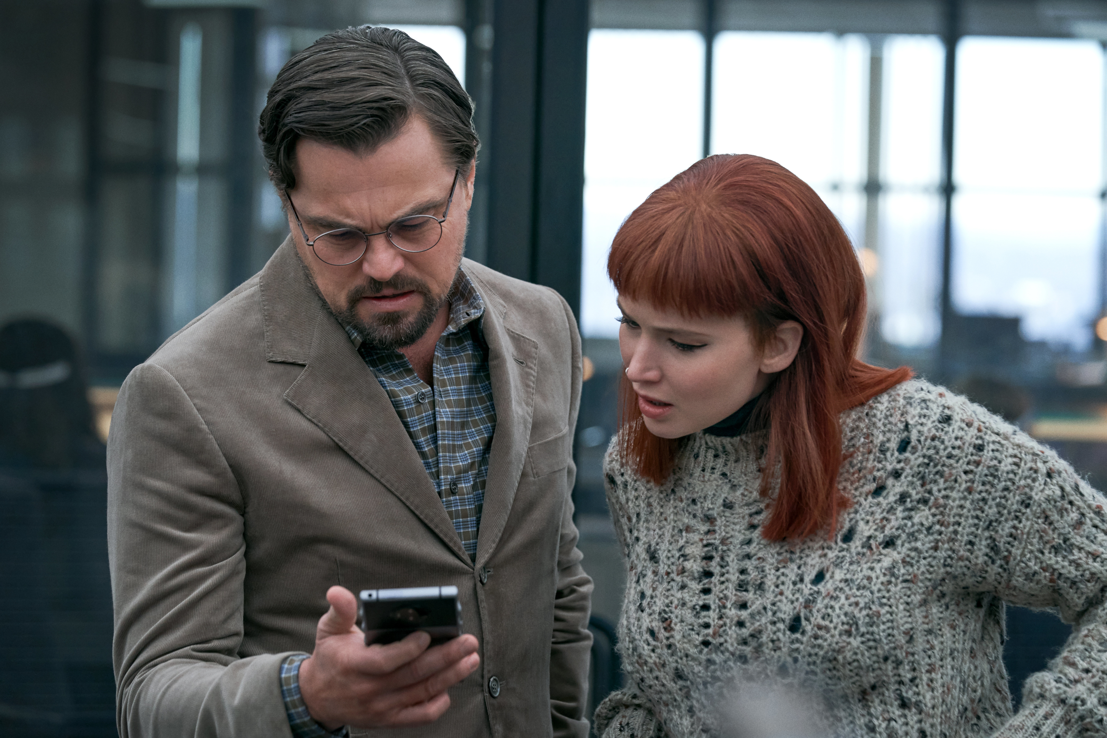 Leonardo DiCaprio and Jennifer Lawrence looking at a phone in Don't Look Up HD Wallpaper