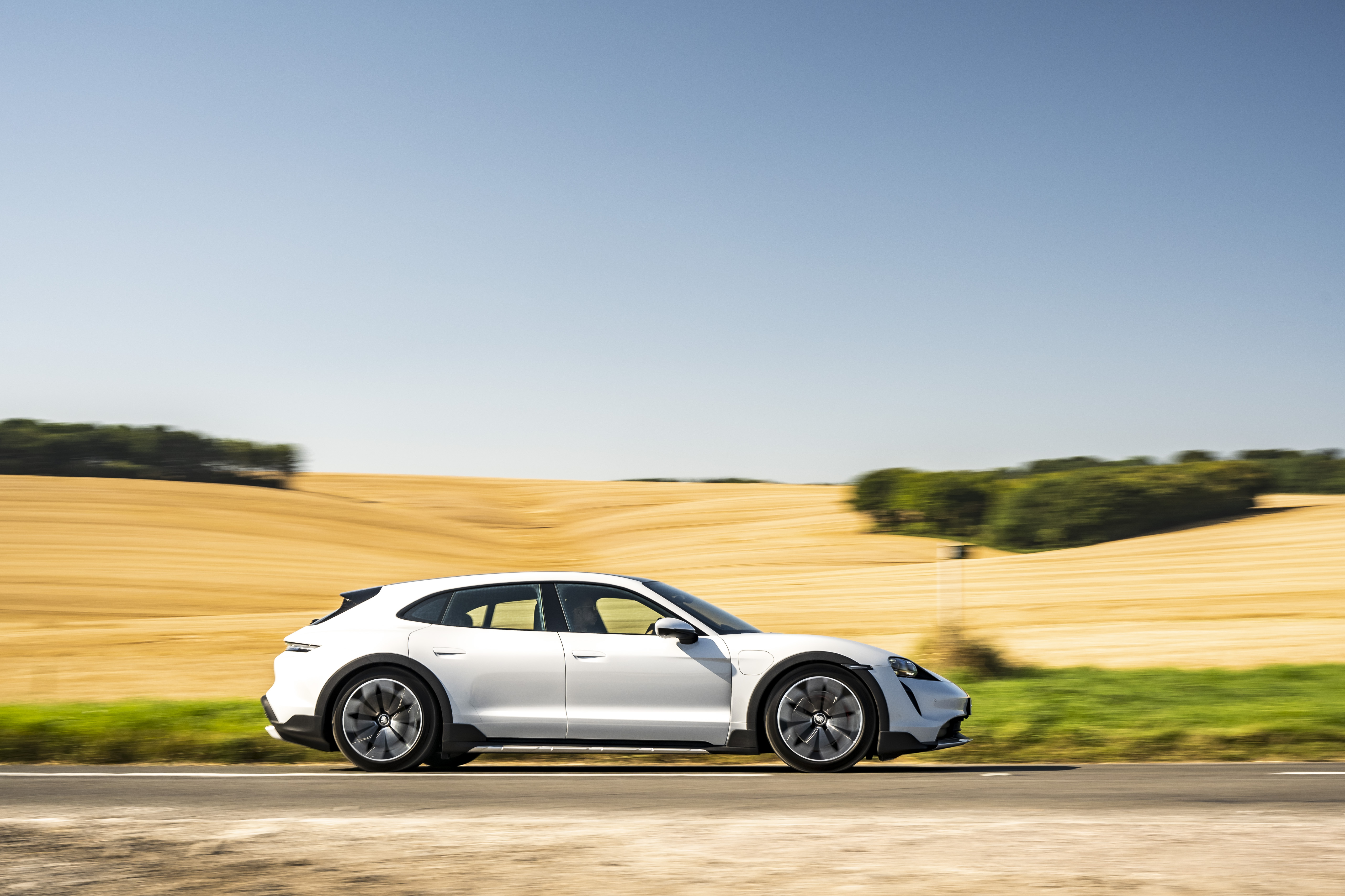 White Porsche Taycan 4S sport car driving through fields HD Wallpaper