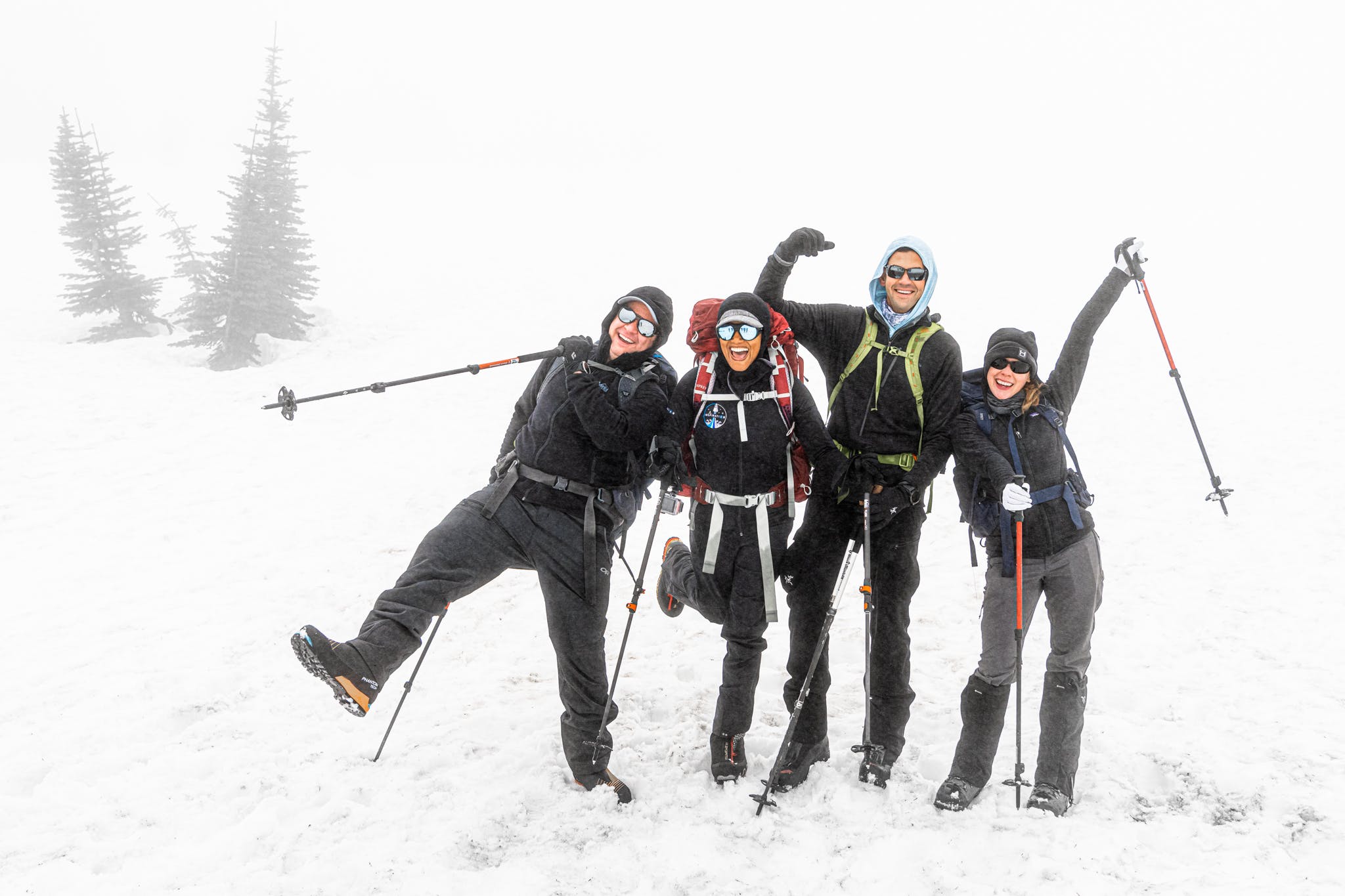 Joyful group hiking in a snowy, foggy landscape HD Wallpaper