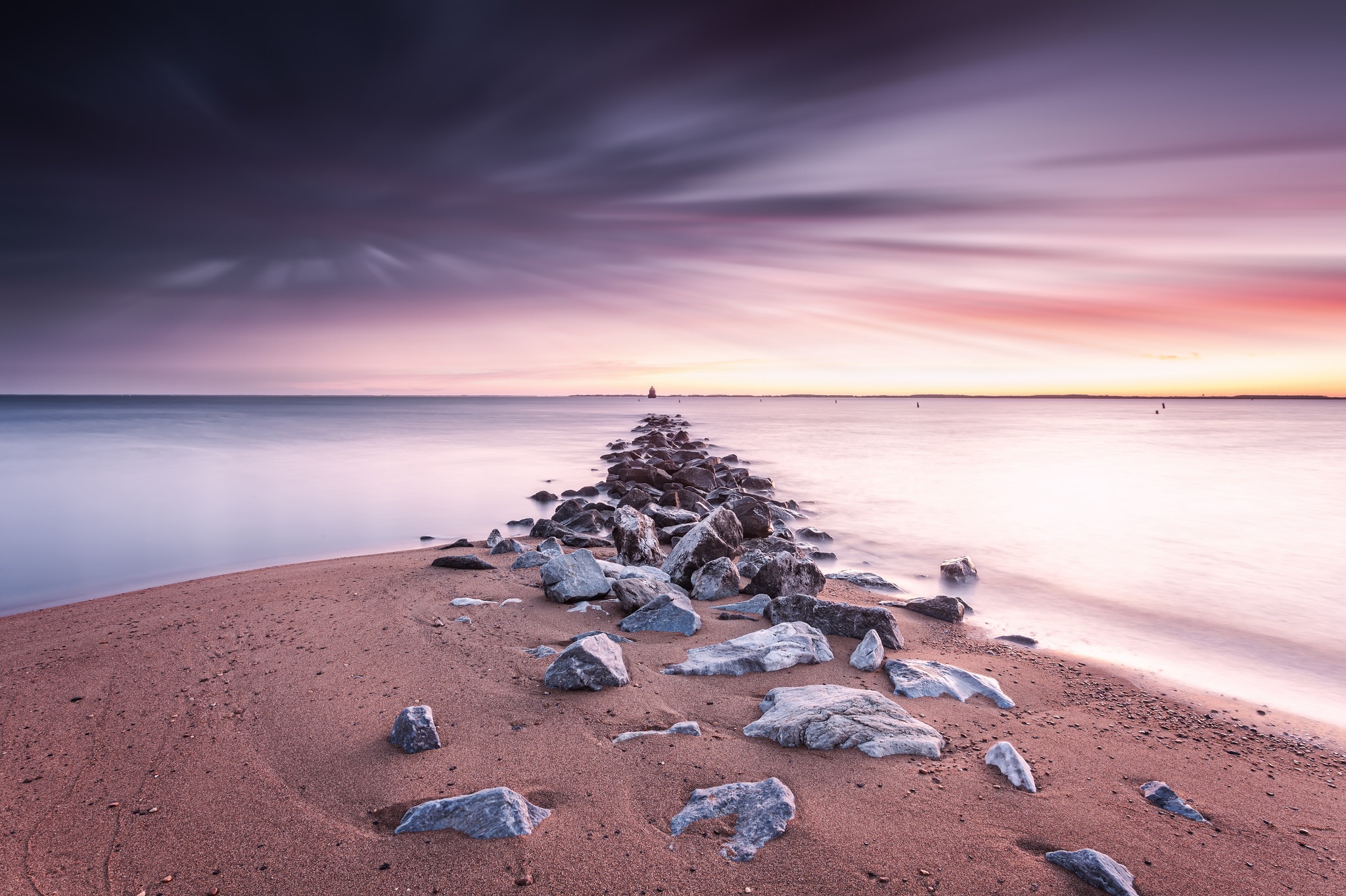 Colorful sunset over ocean with rocky path to horizon HD Wallpaper