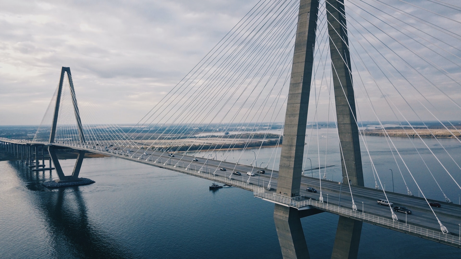 Grey suspension bridge over water with cars HD Wallpaper