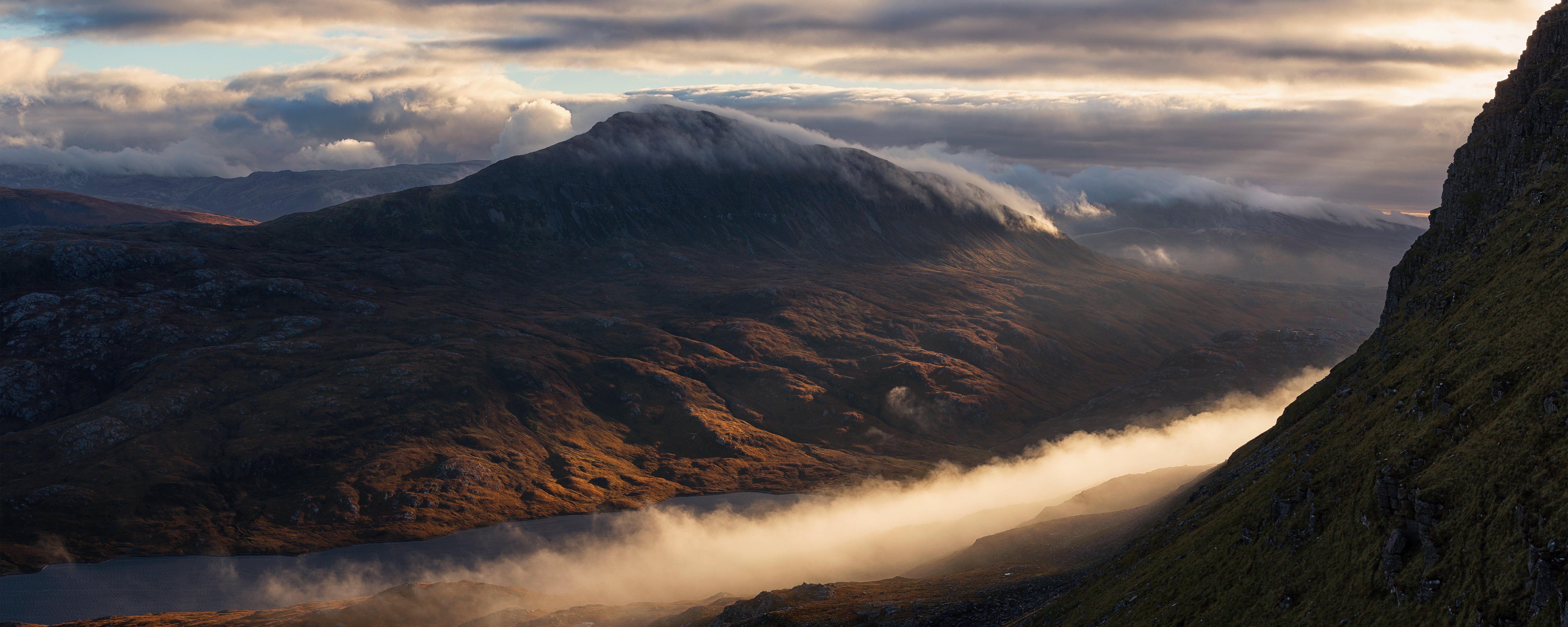 Golden light on mountain peak with flowing clouds and mist HD Wallpaper