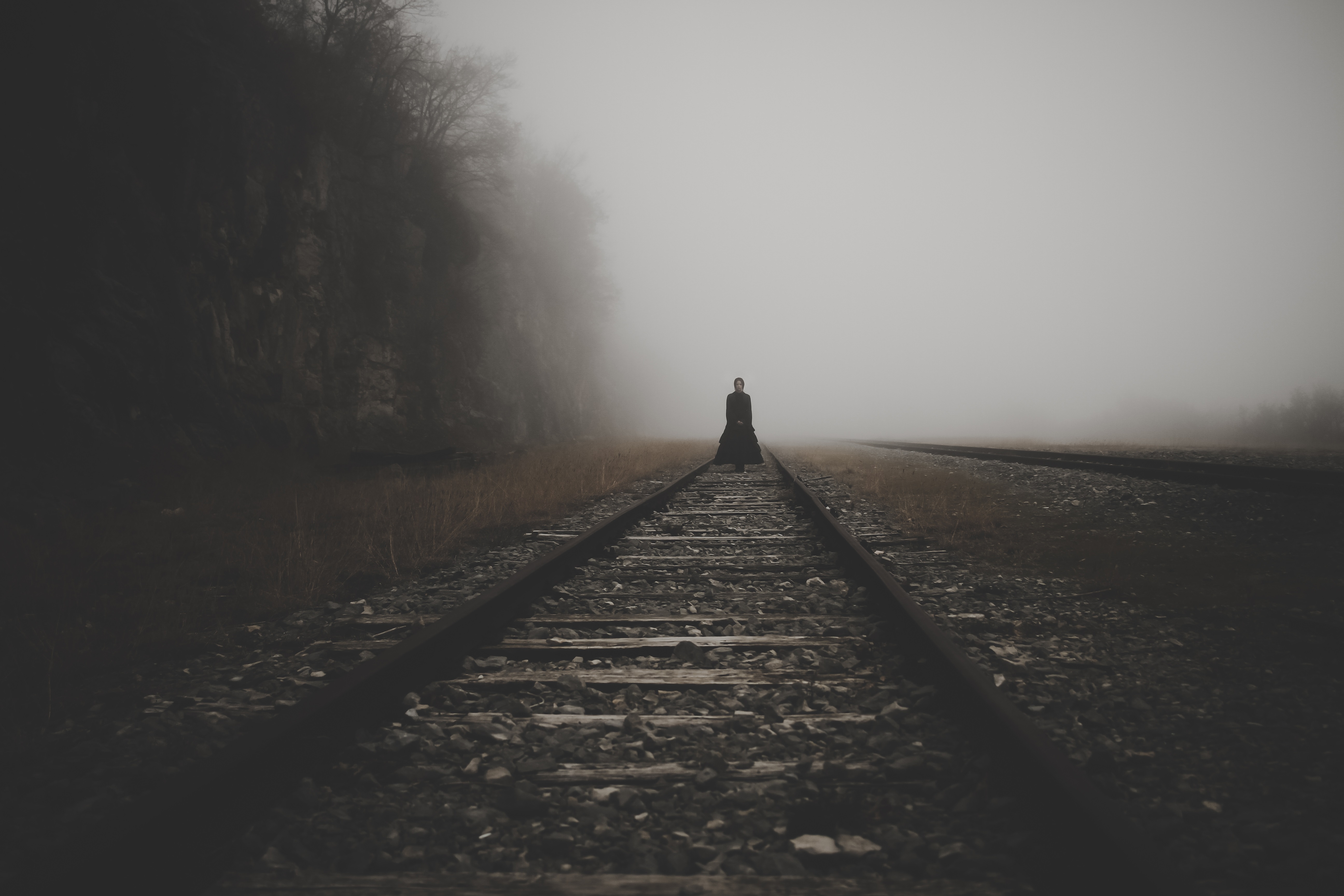 Woman in black on foggy railroad tracks HD Wallpaper
