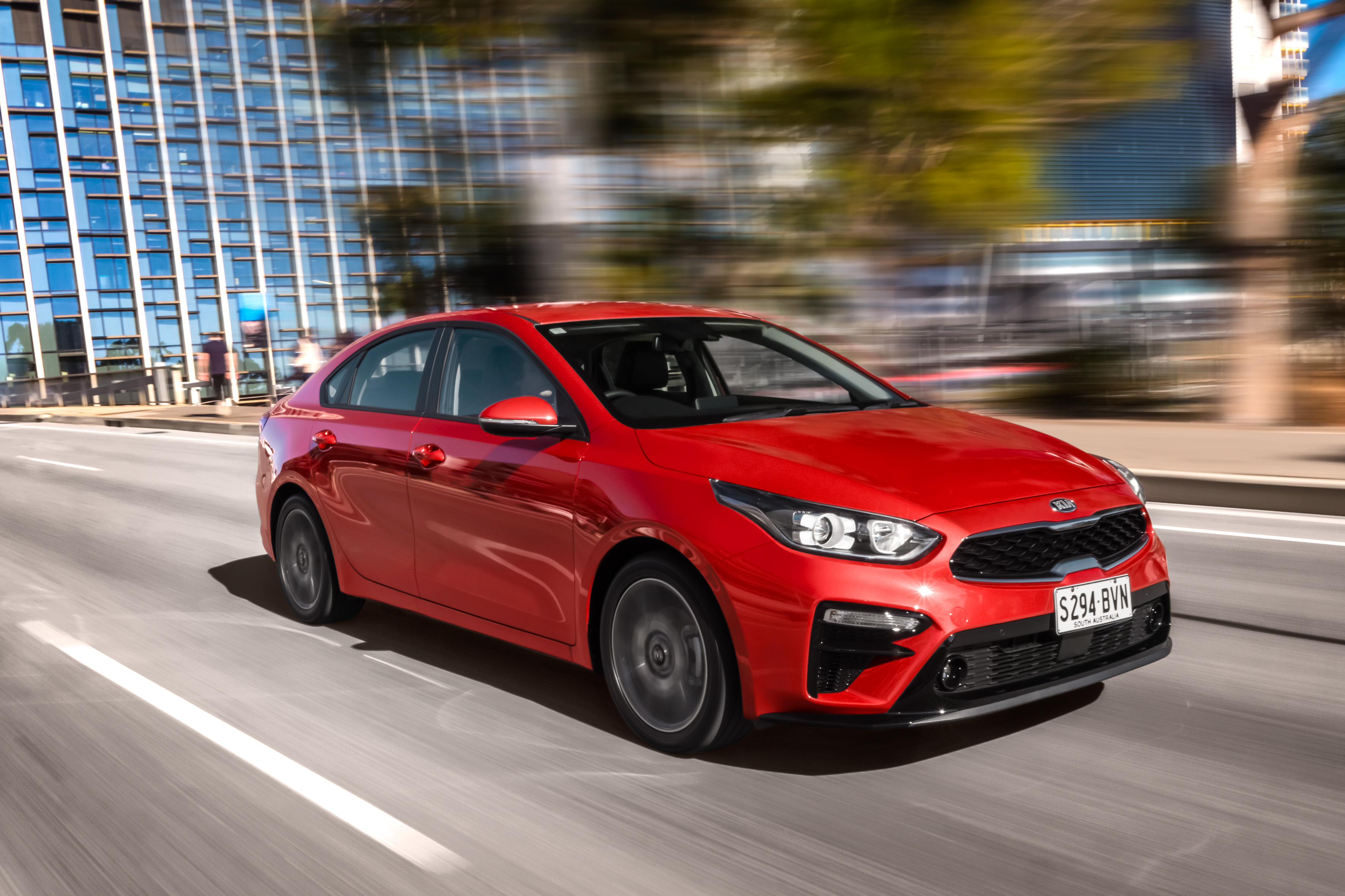 Red Kia Cerato Sport Plus compact car in motion HD Wallpaper