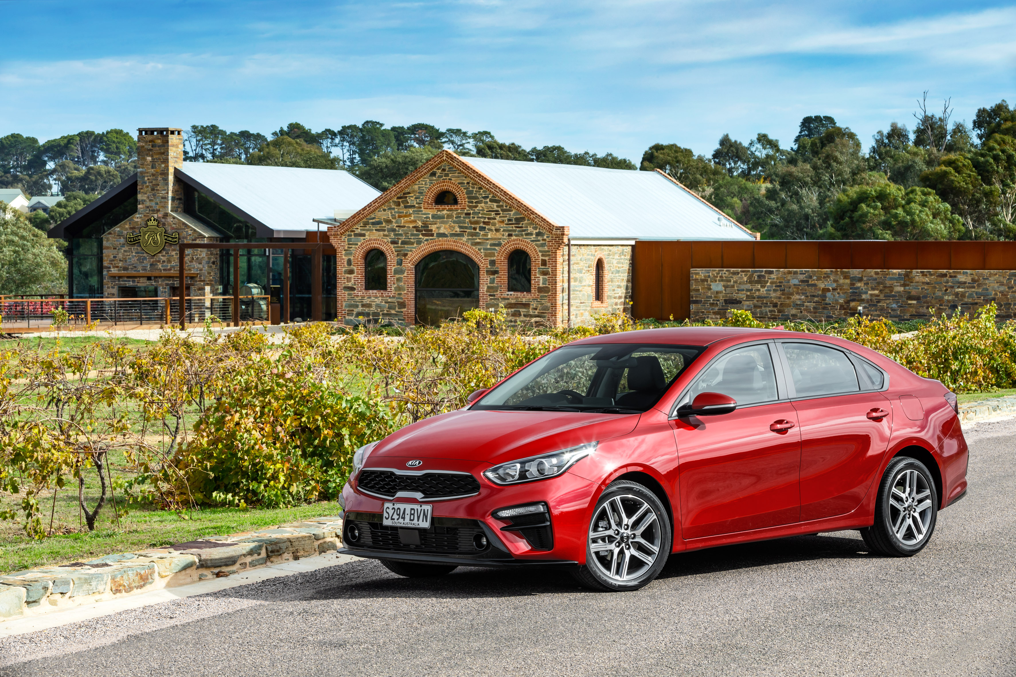 Red Kia Cerato parked at a winery HD Wallpaper