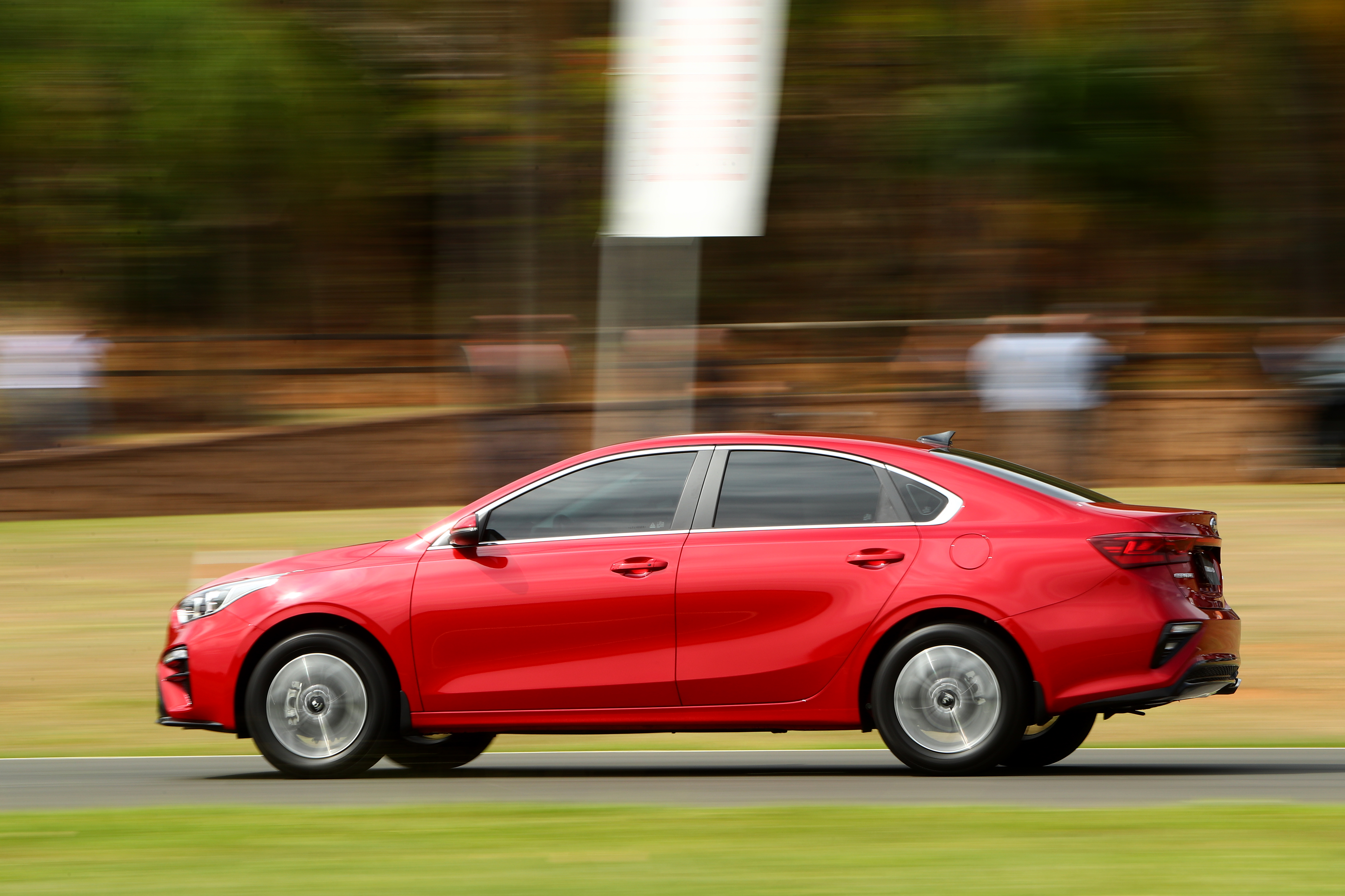 Red Kia Cerato compact car in motion HD Wallpaper