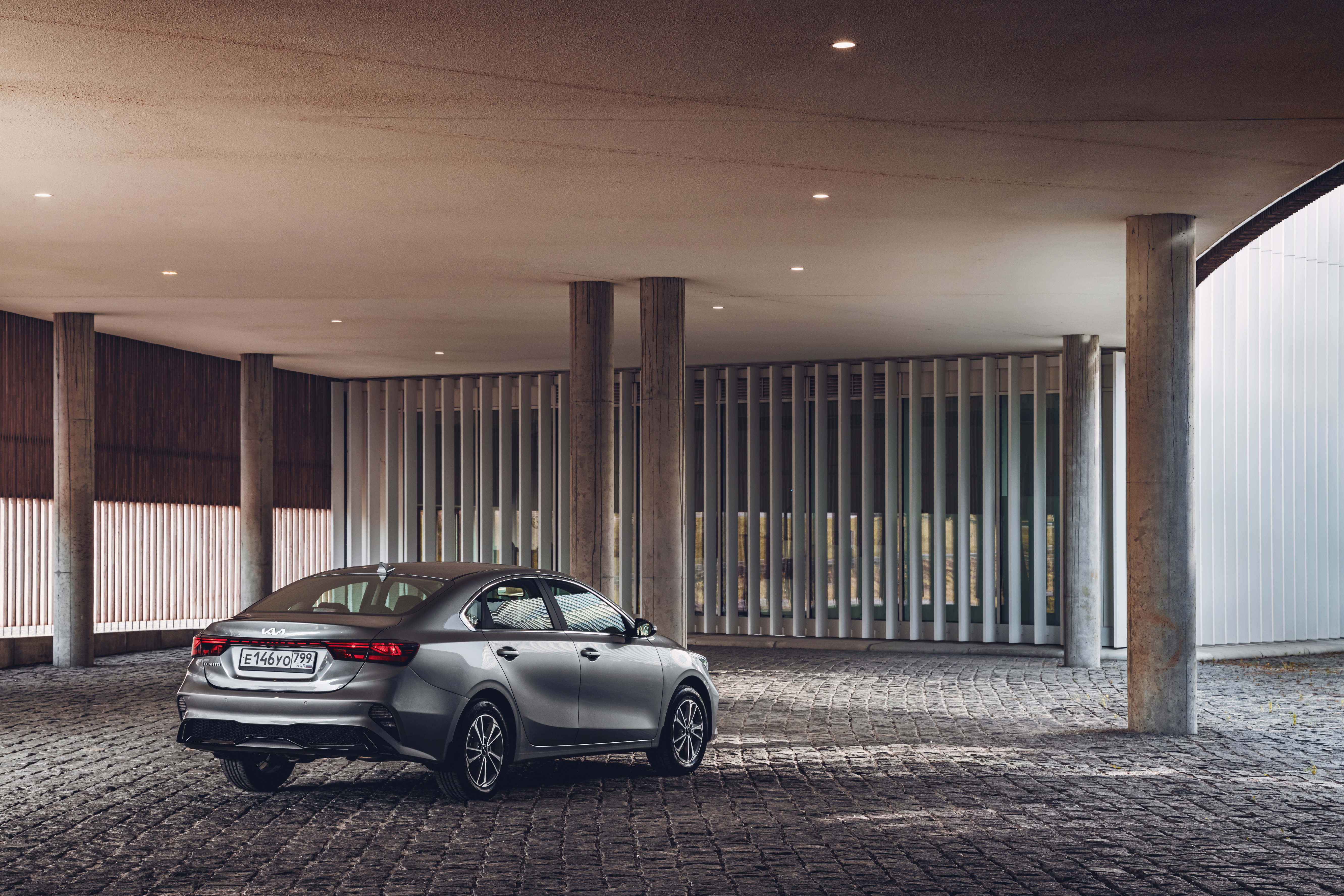 Kia Cerato compact car in modern architectural setting HD Wallpaper