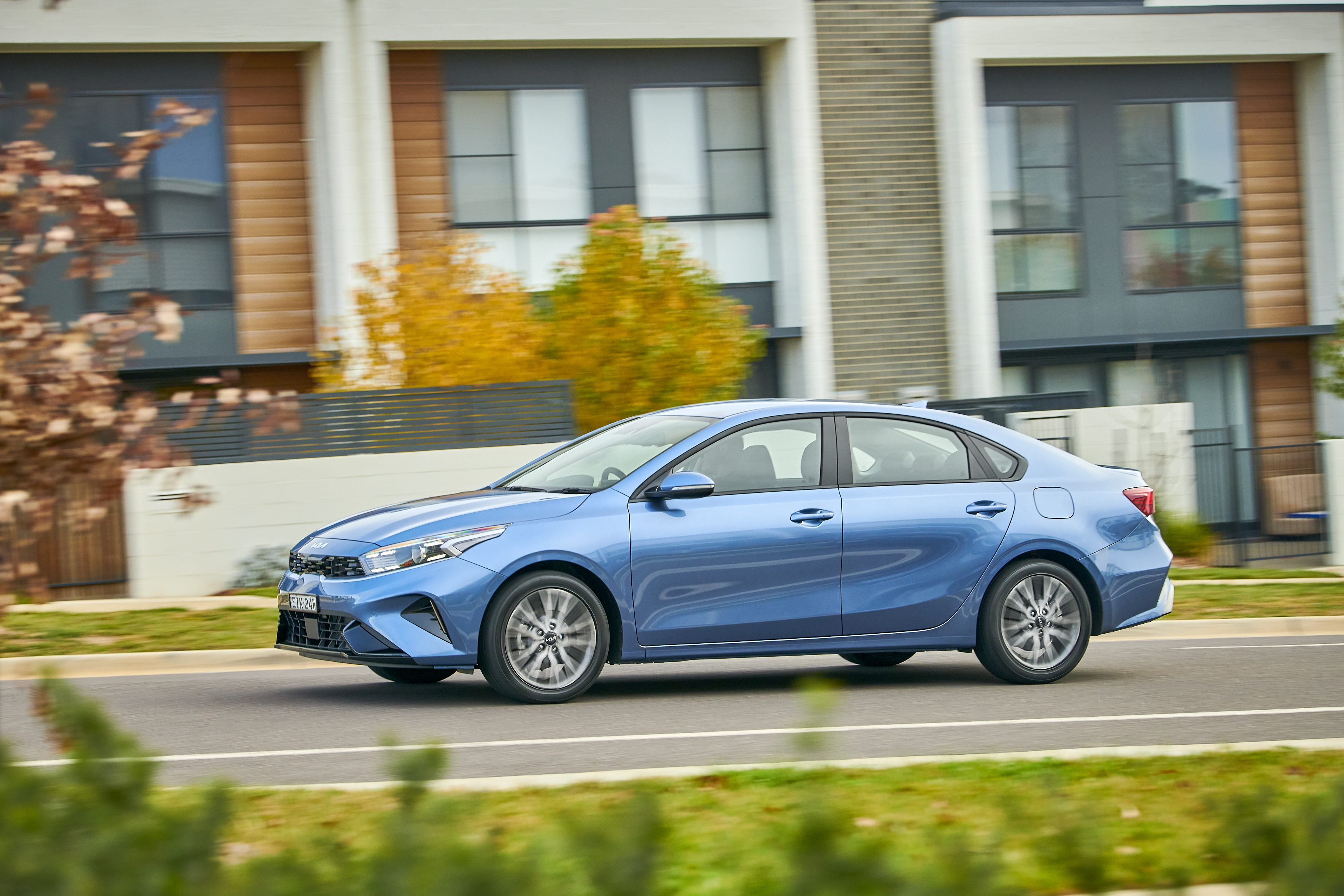 Blue Kia Cerato Sport Plus compact car driving on road HD Wallpaper