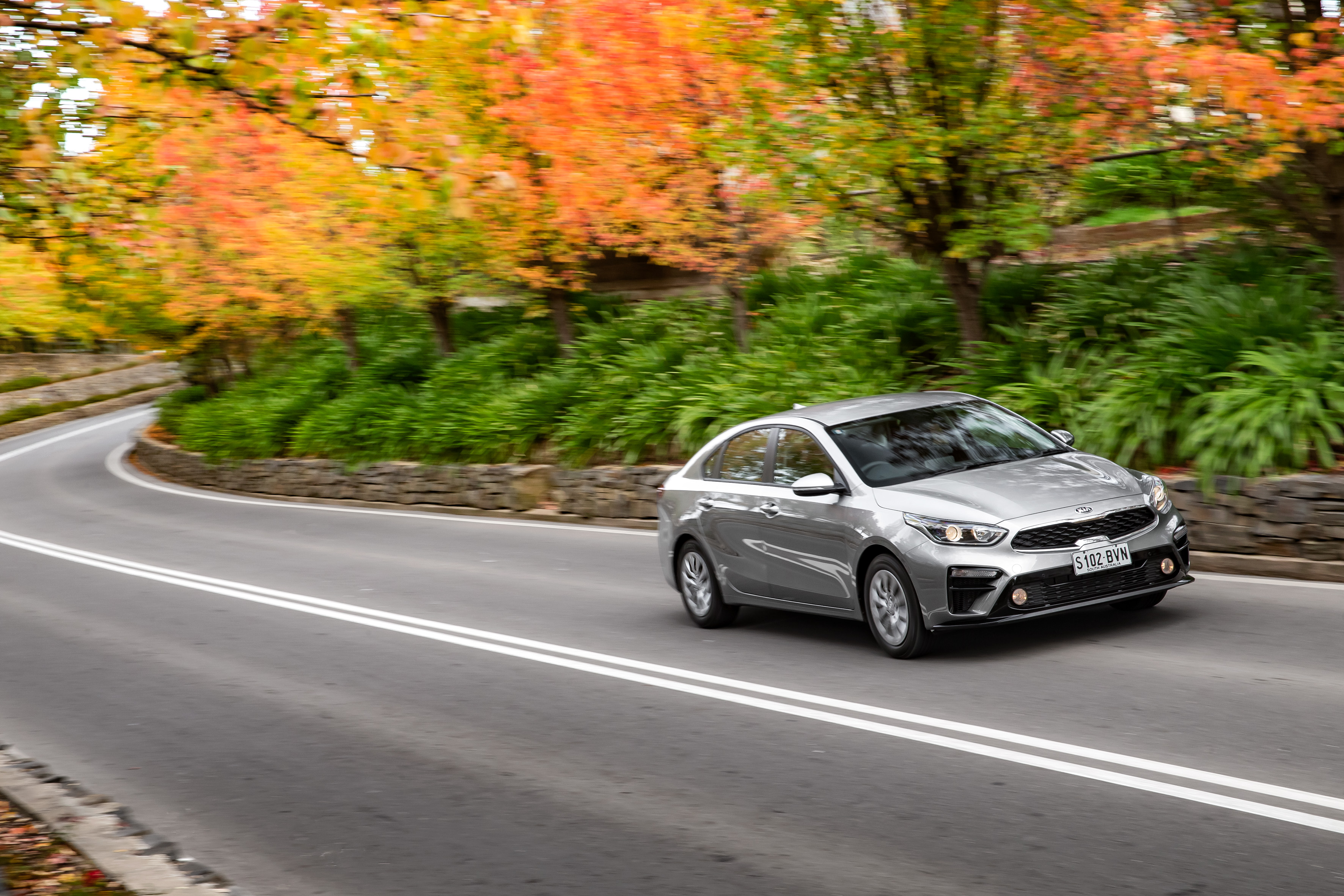Silver Kia Cerato S driving on autumn road HD Wallpaper
