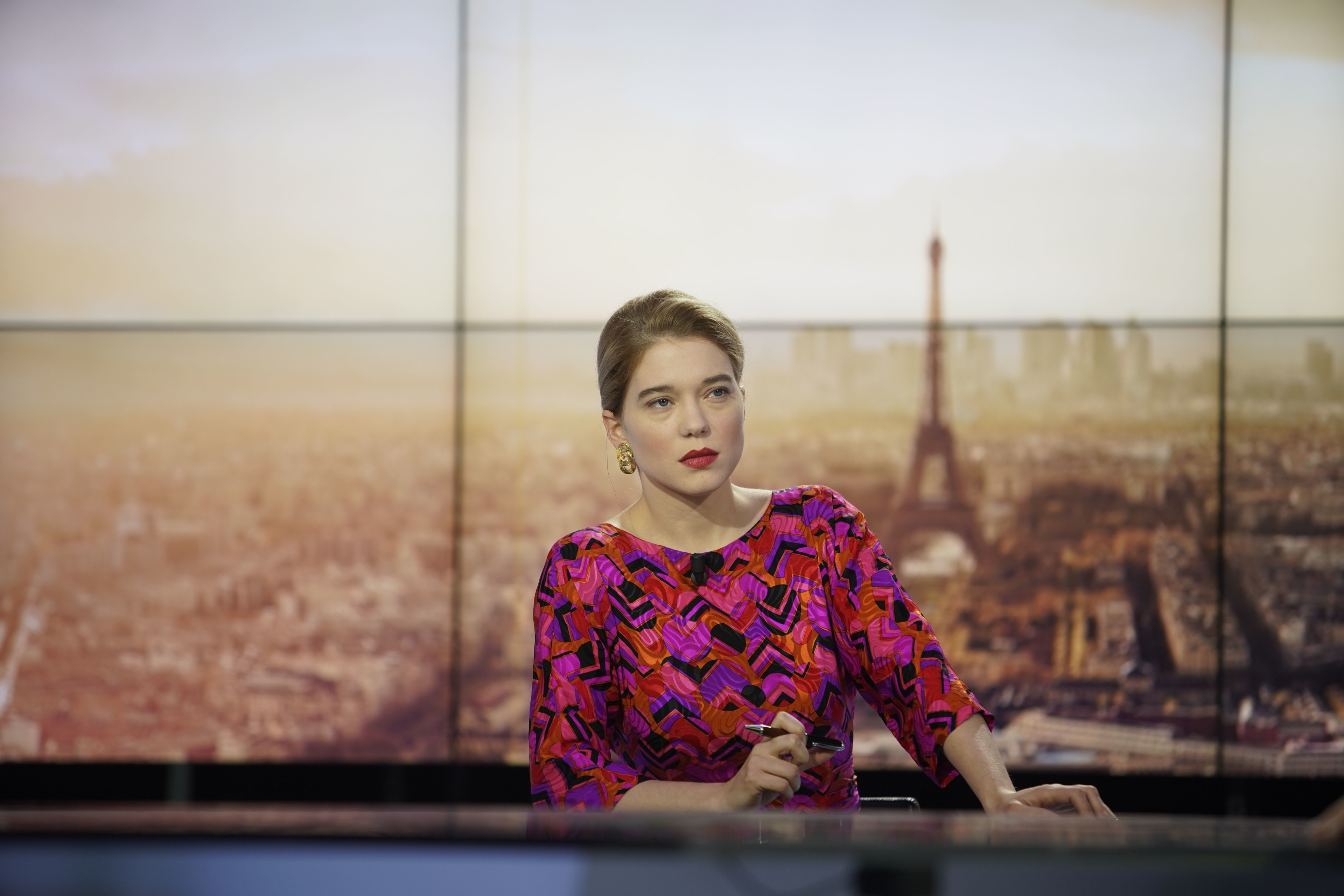 Léa Seydoux at a desk with Paris cityscape HD Wallpaper