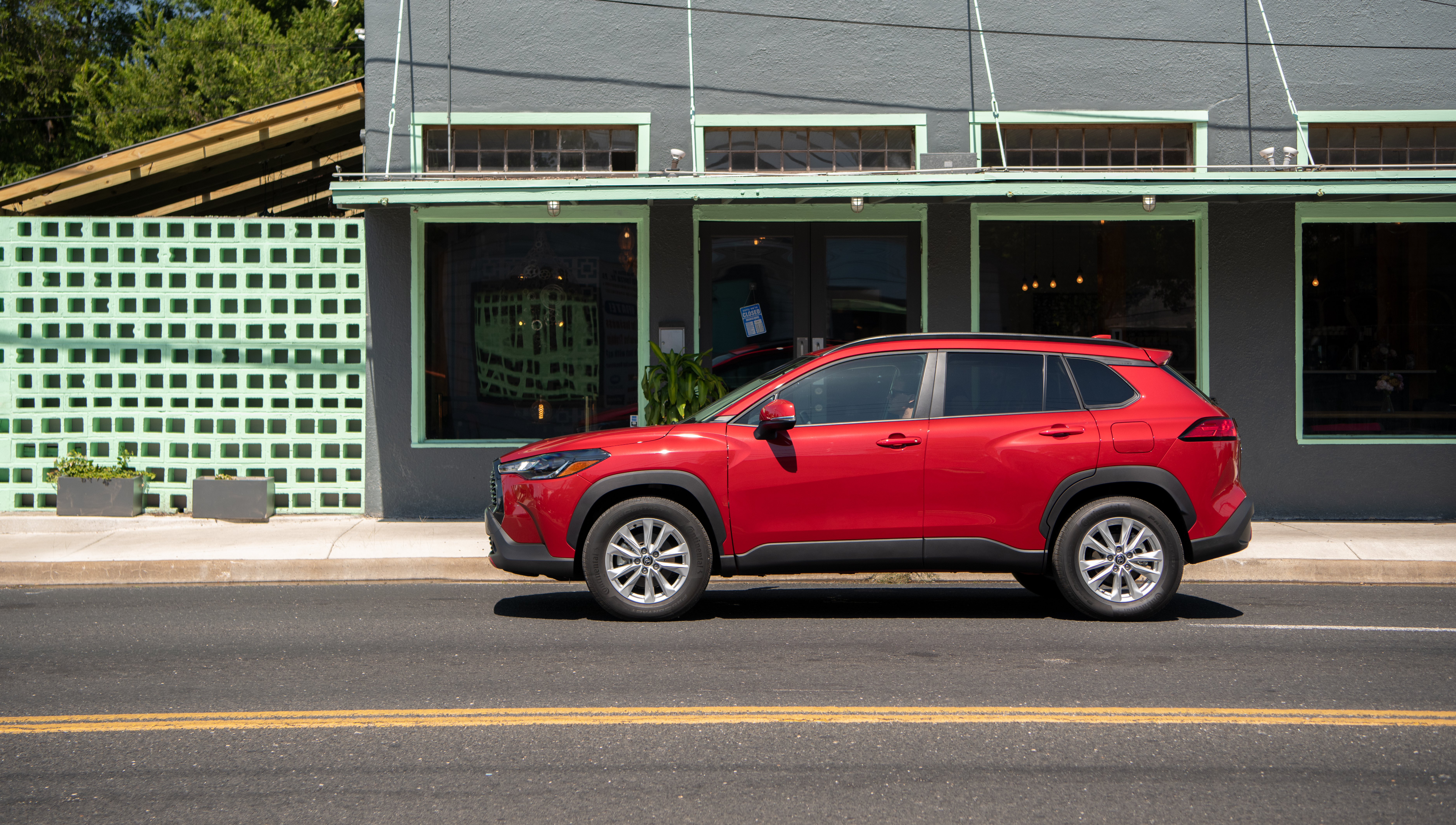 Red Toyota Corolla Cross SUV parked on street HD Wallpaper