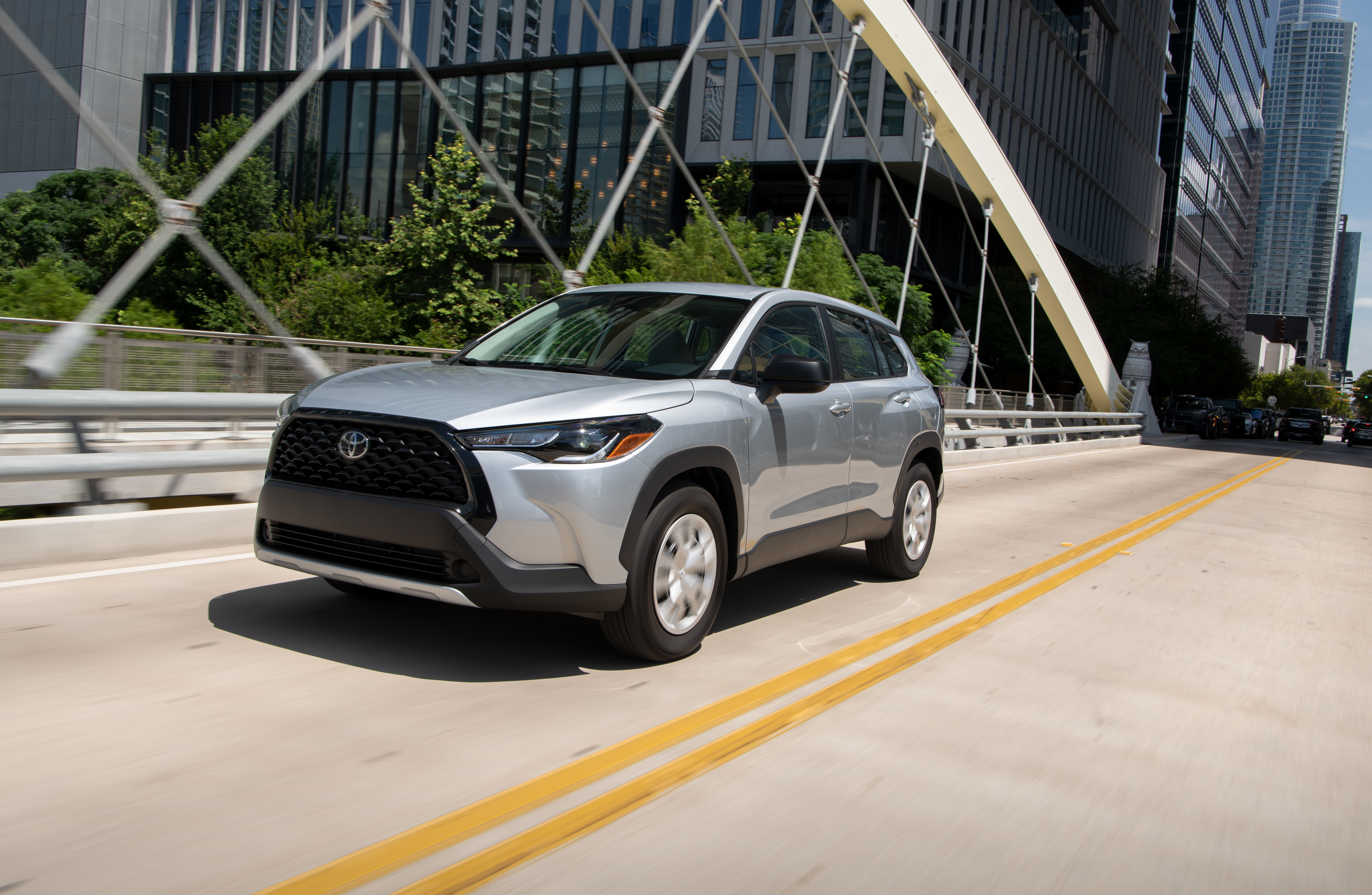 Silver Toyota Corolla Cross L SUV on a city bridge HD Wallpaper