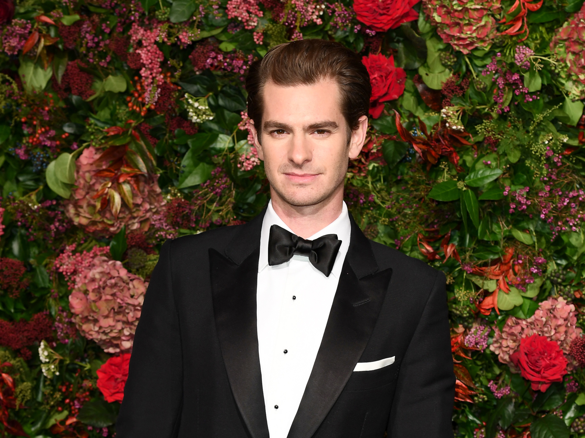 Andrew Garfield in tuxedo against a flower wall HD Wallpaper