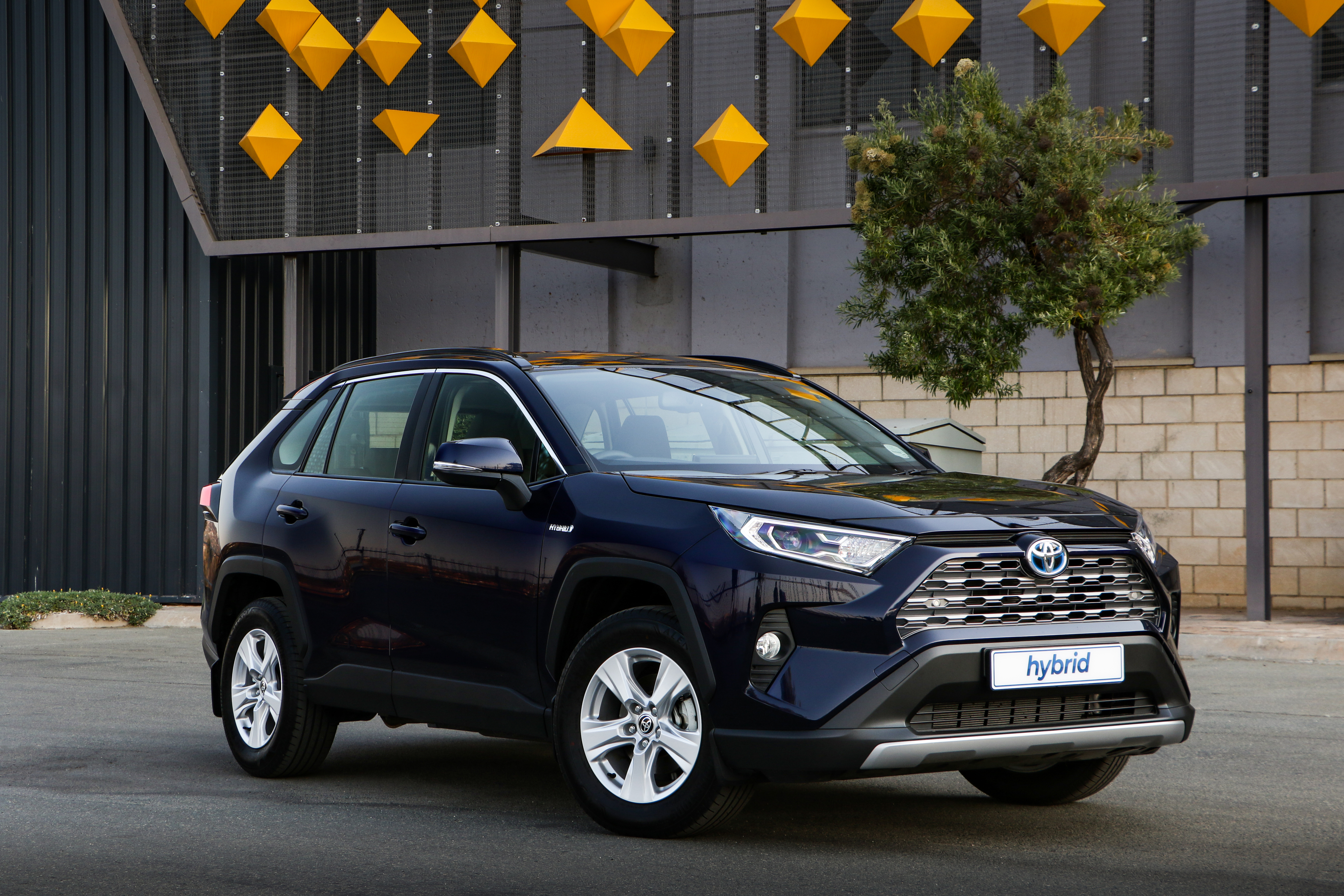 Dark Blue Toyota RAV4 Hybrid SUV with Yellow Geometric Decor HD Wallpaper