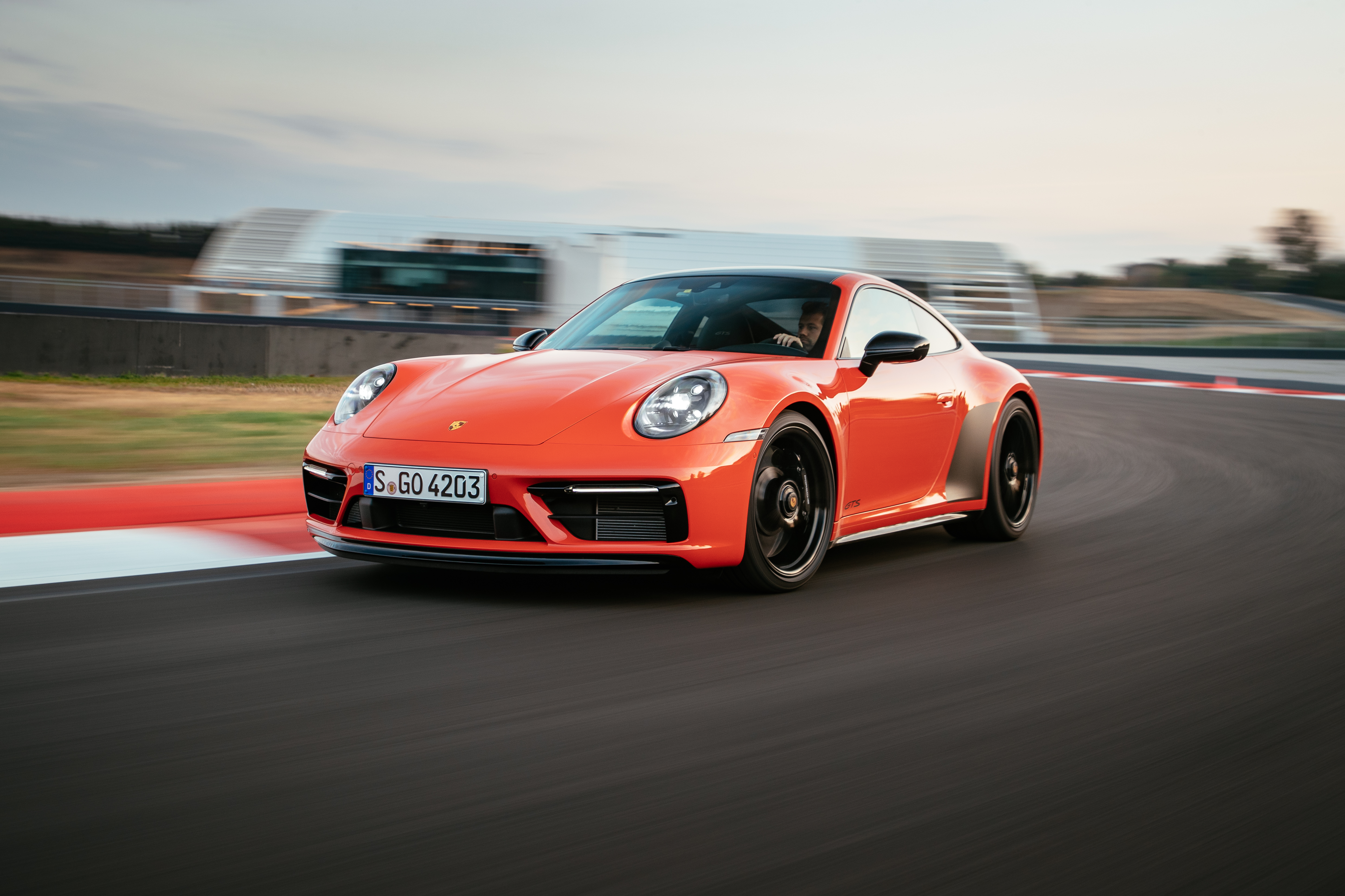 Orange Porsche 911 Carrera GTS on race track HD Wallpaper