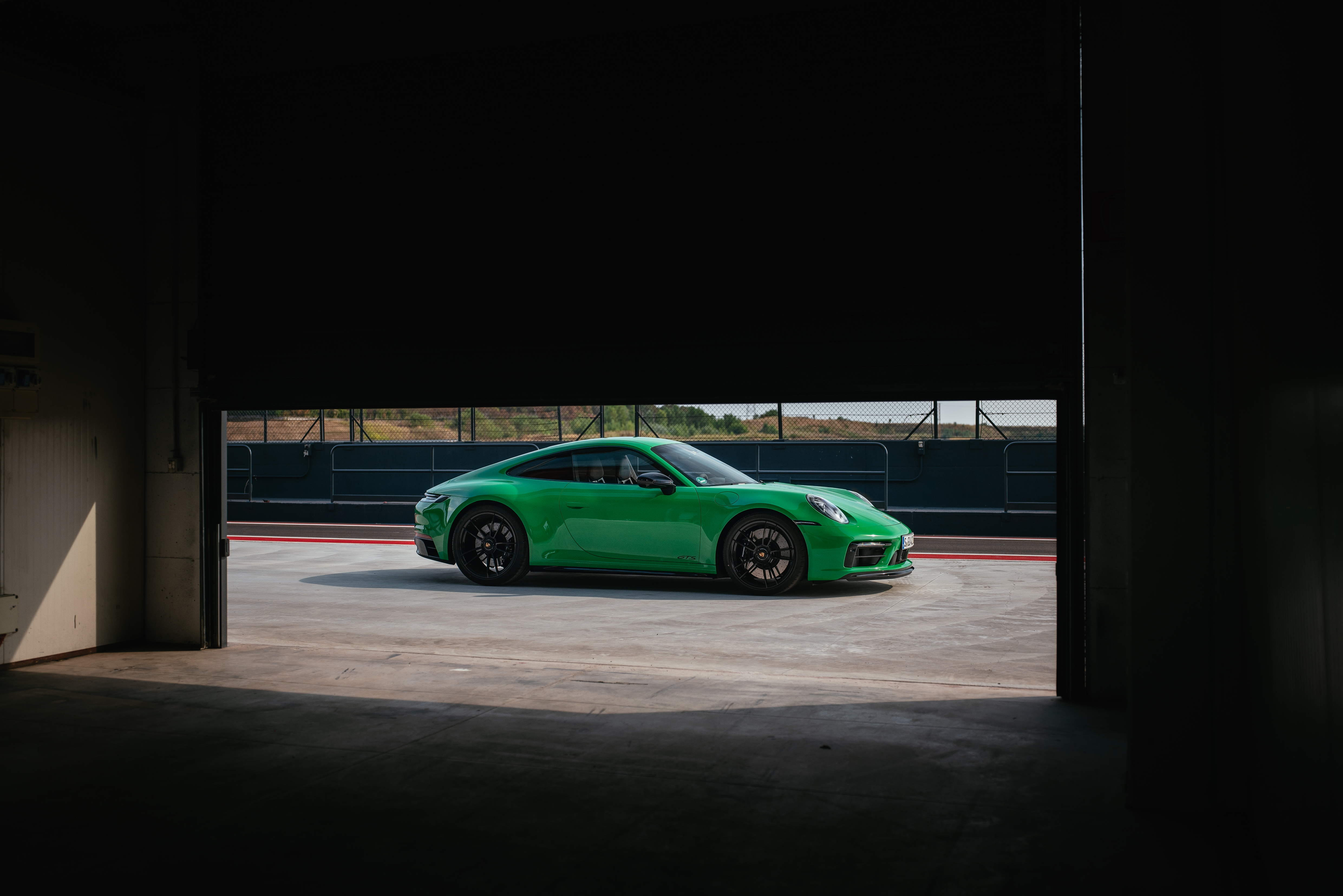 Green Porsche 911 Carrera GTS in pit lane HD Wallpaper