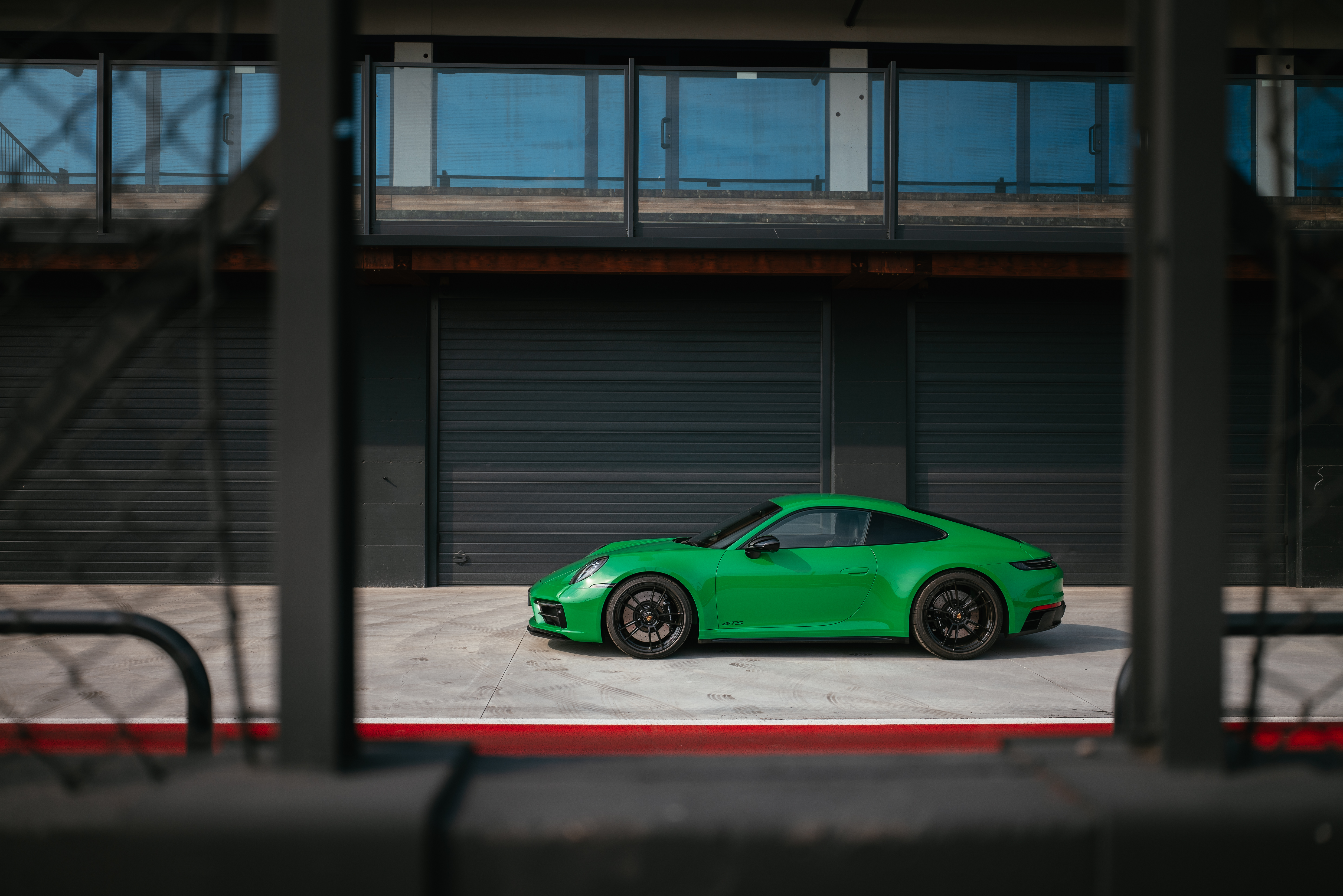 Green Porsche 911 Carrera GTS sport car behind a fence HD Wallpaper