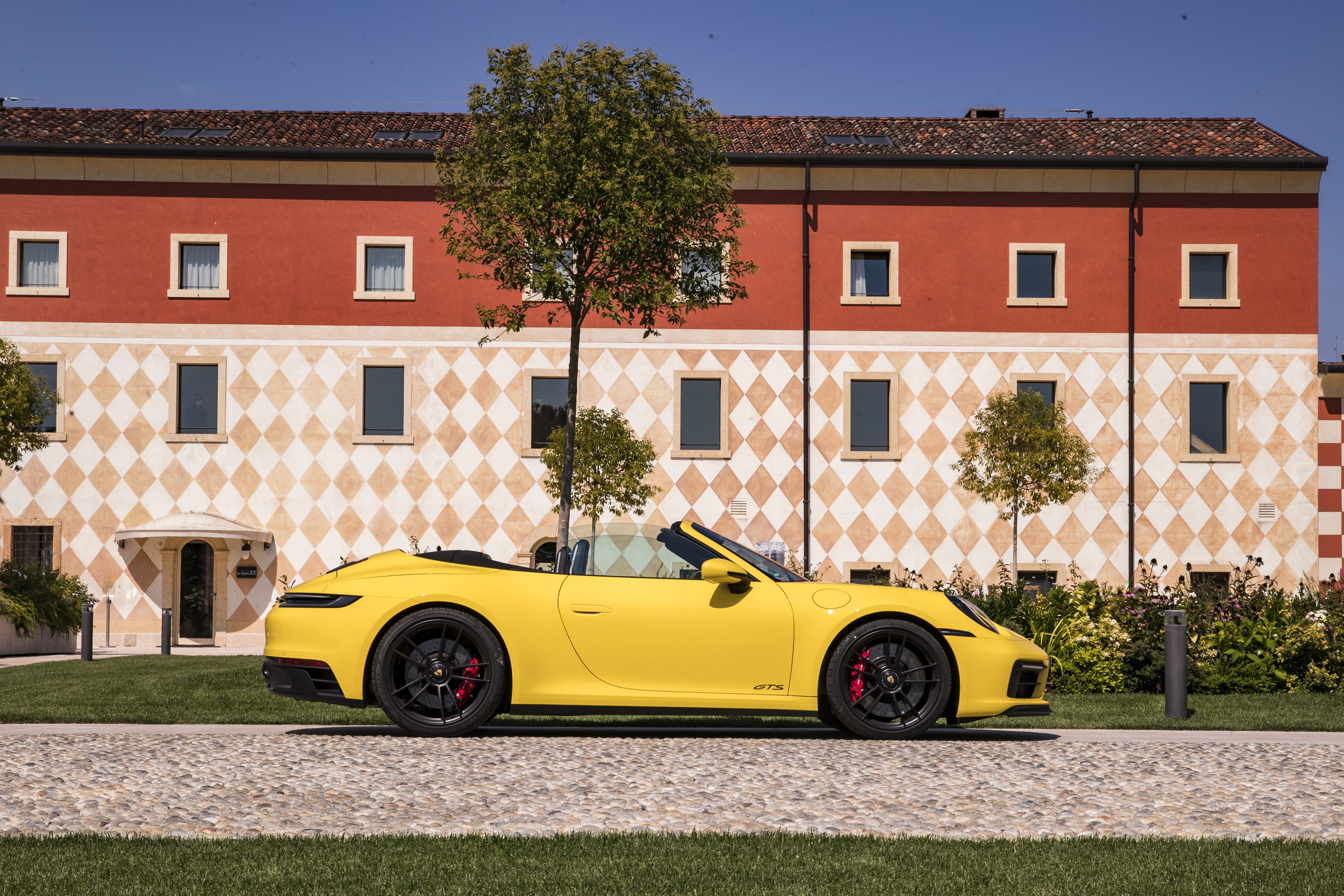 Yellow Porsche 911 GTS Cabriolet parked by a building HD Wallpaper