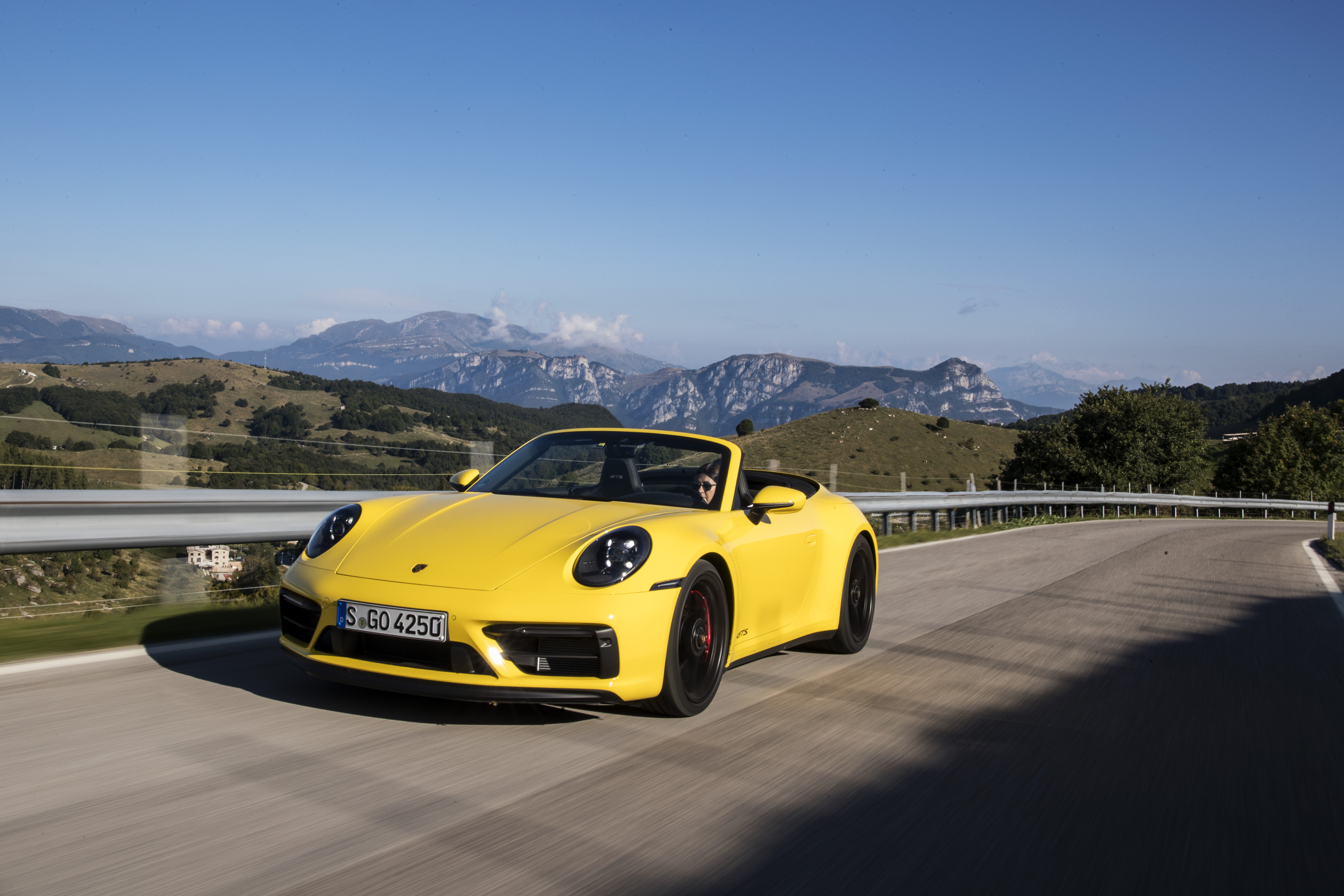 Yellow Porsche 911 Carrera GTS Cabriolet on mountain road HD Wallpaper