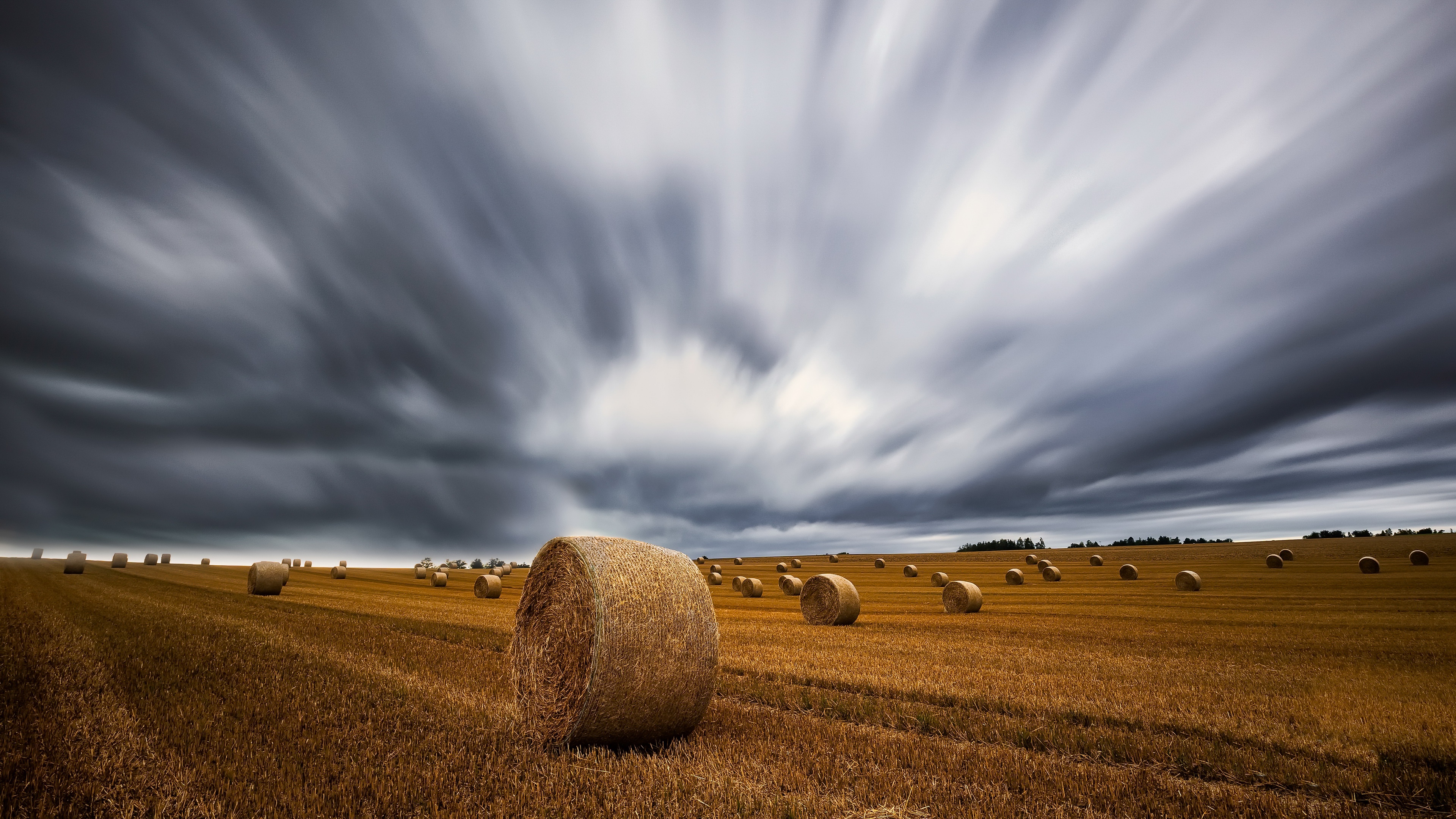 Haystack field under dramatic sky HD Wallpaper