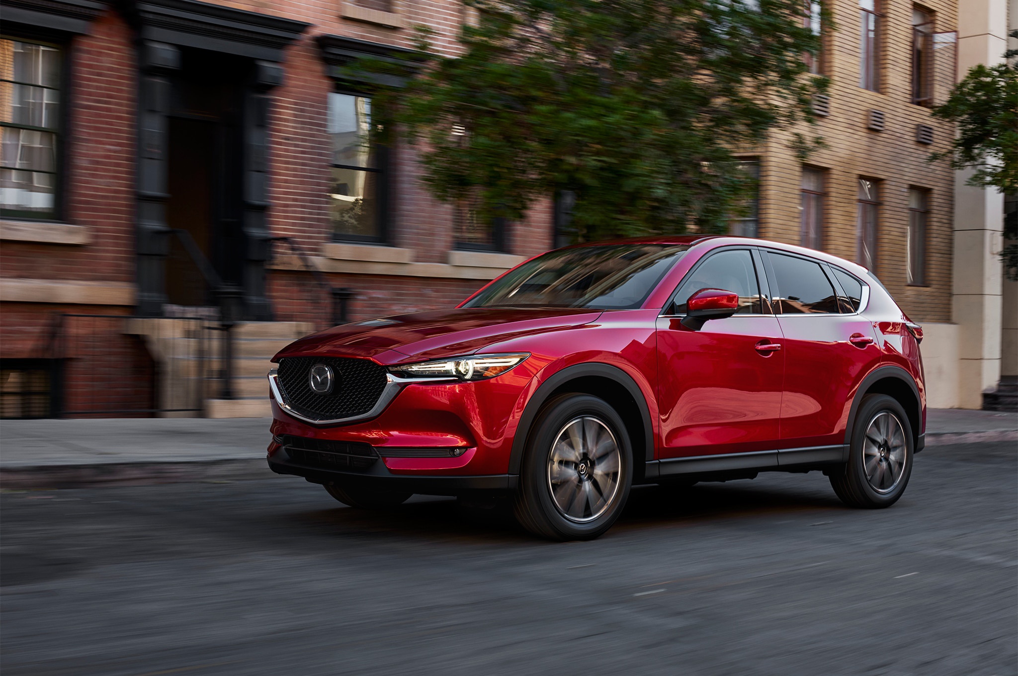 Red Mazda CX-5 SUV driving on city street HD Wallpaper