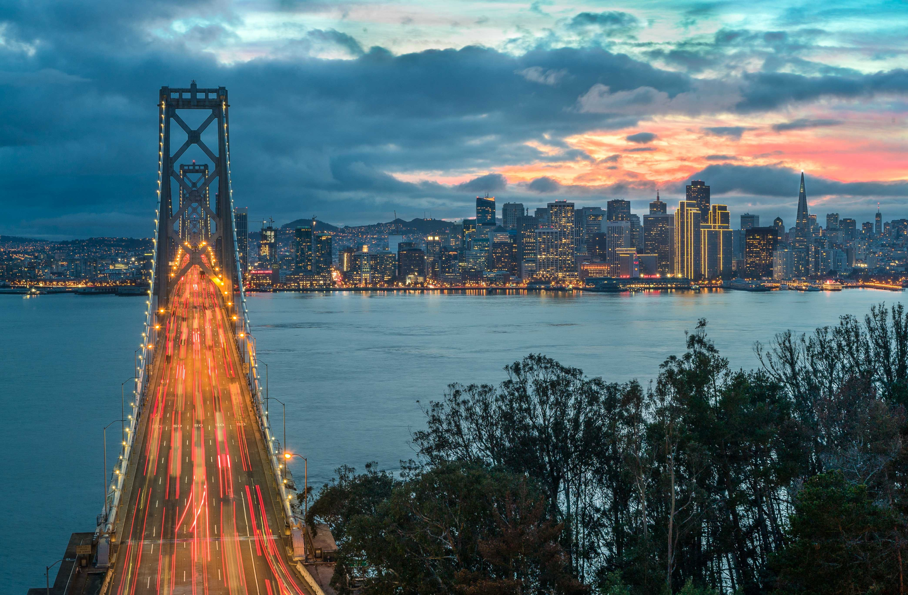 San Francisco Bay Bridge and city skyline at sunset HD Wallpaper