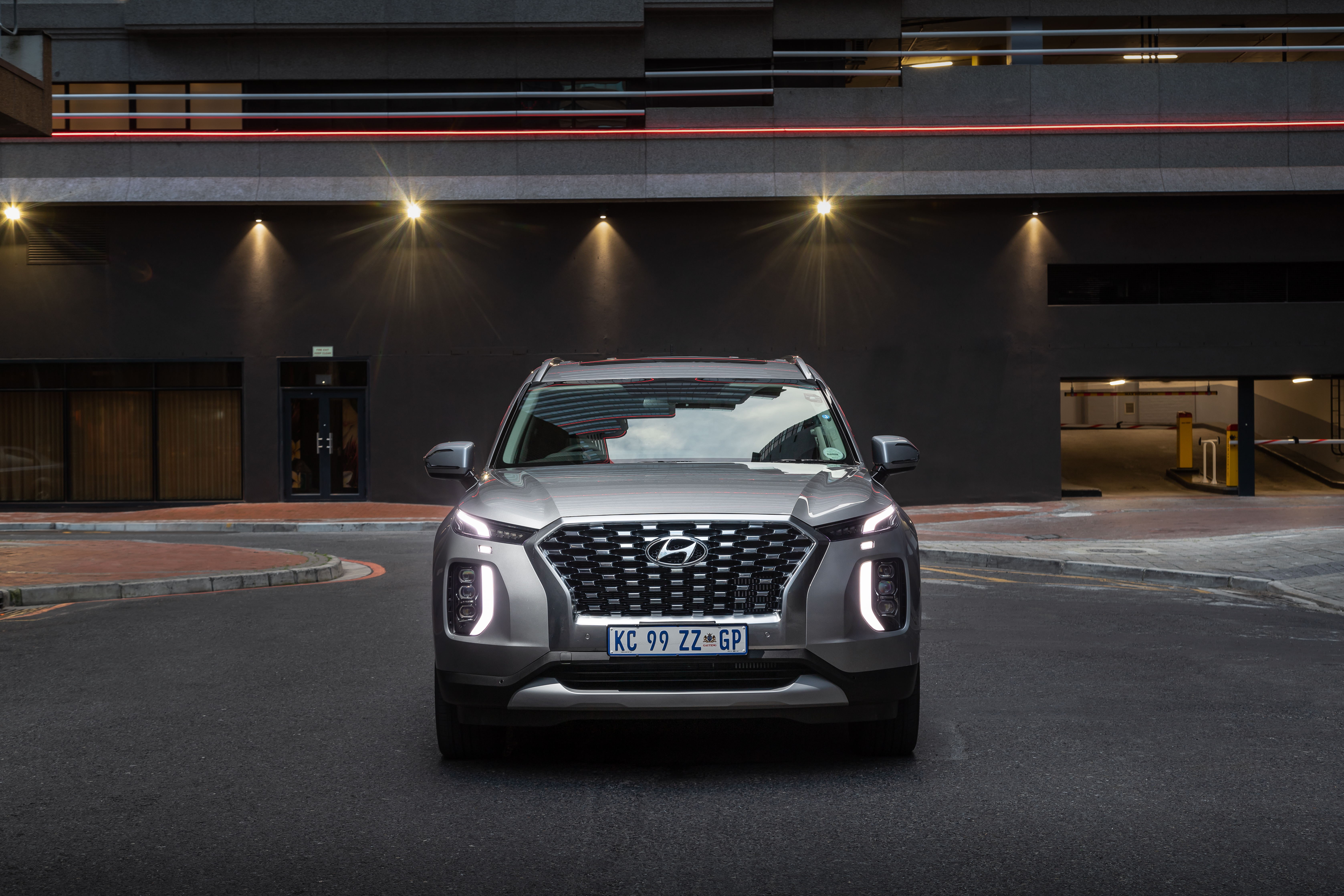 Hyundai Palisade SUV in front of illuminated building HD Wallpaper
