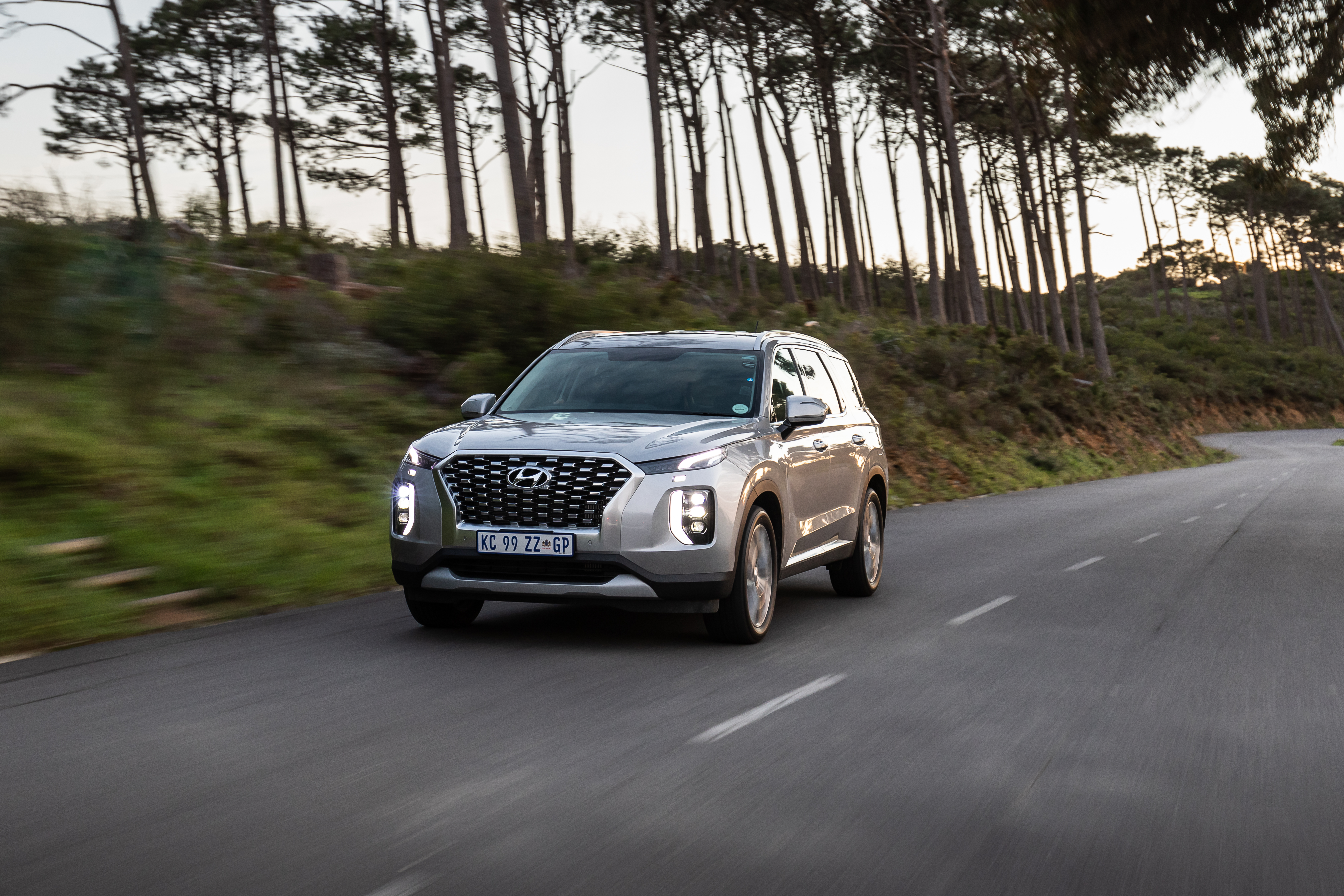 Silver Hyundai Palisade SUV driving on a winding road HD Wallpaper