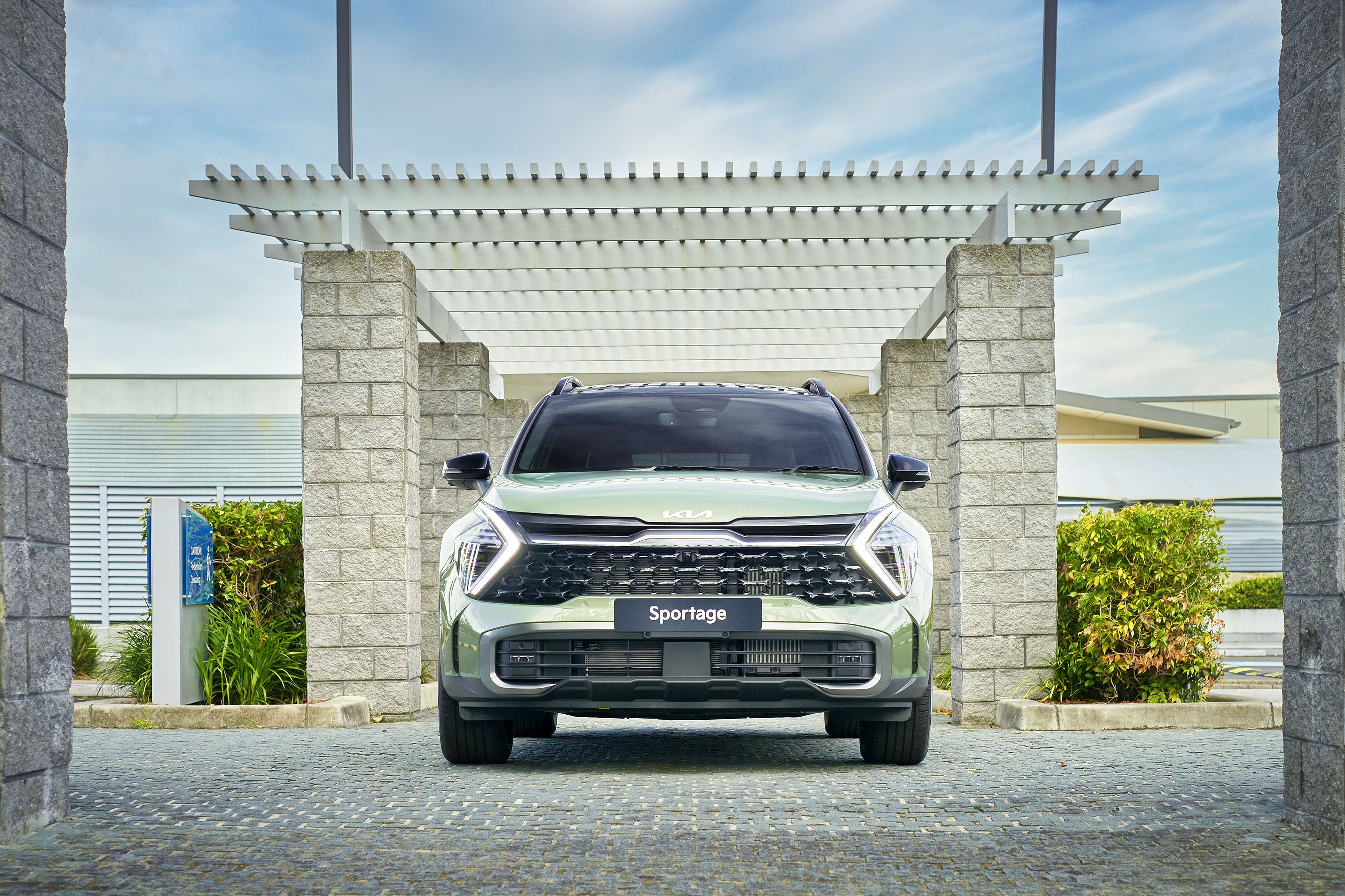Green Kia Sportage SUV parked under a pergola HD Wallpaper