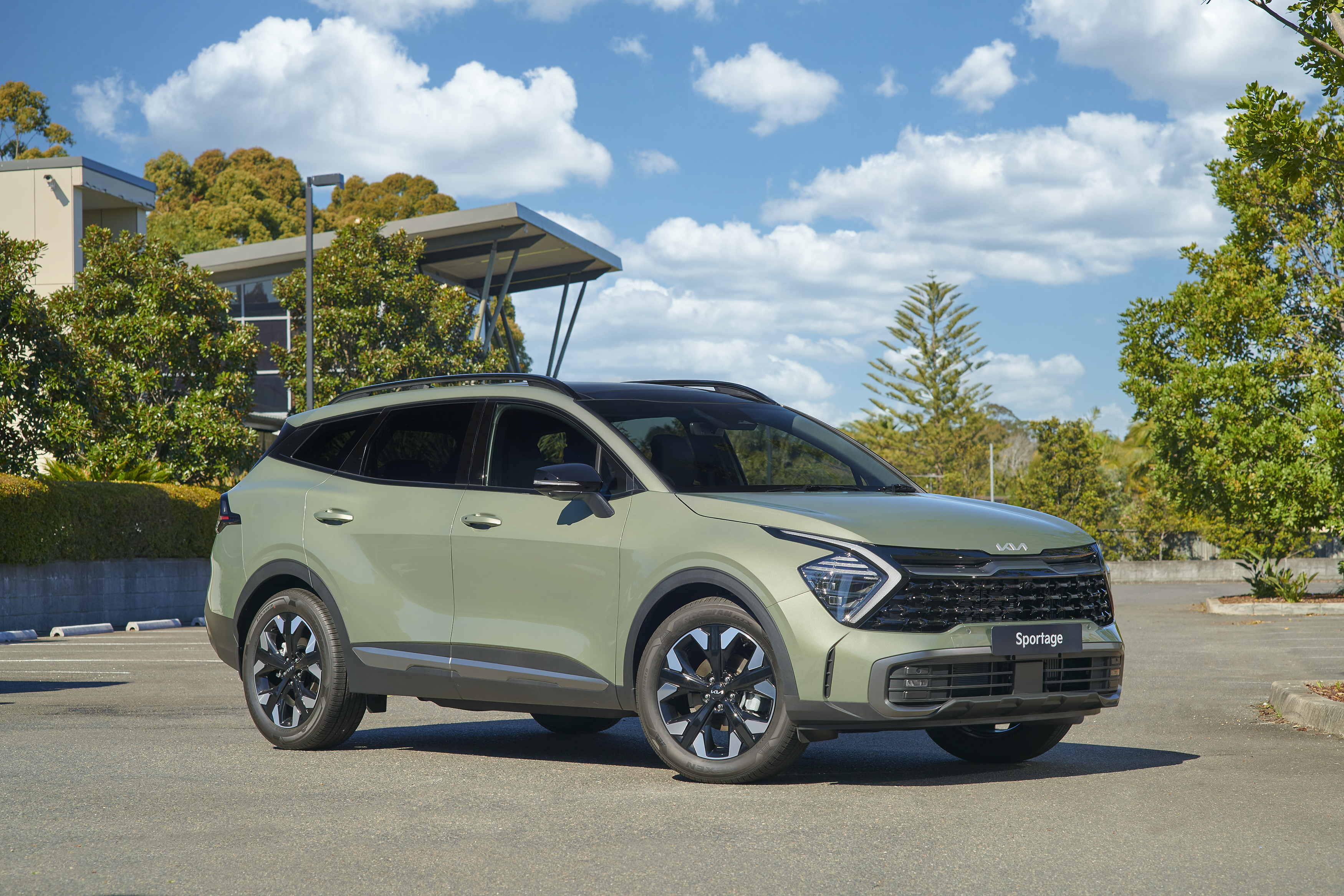 Green Kia Sportage SUV parked outdoors HD Wallpaper