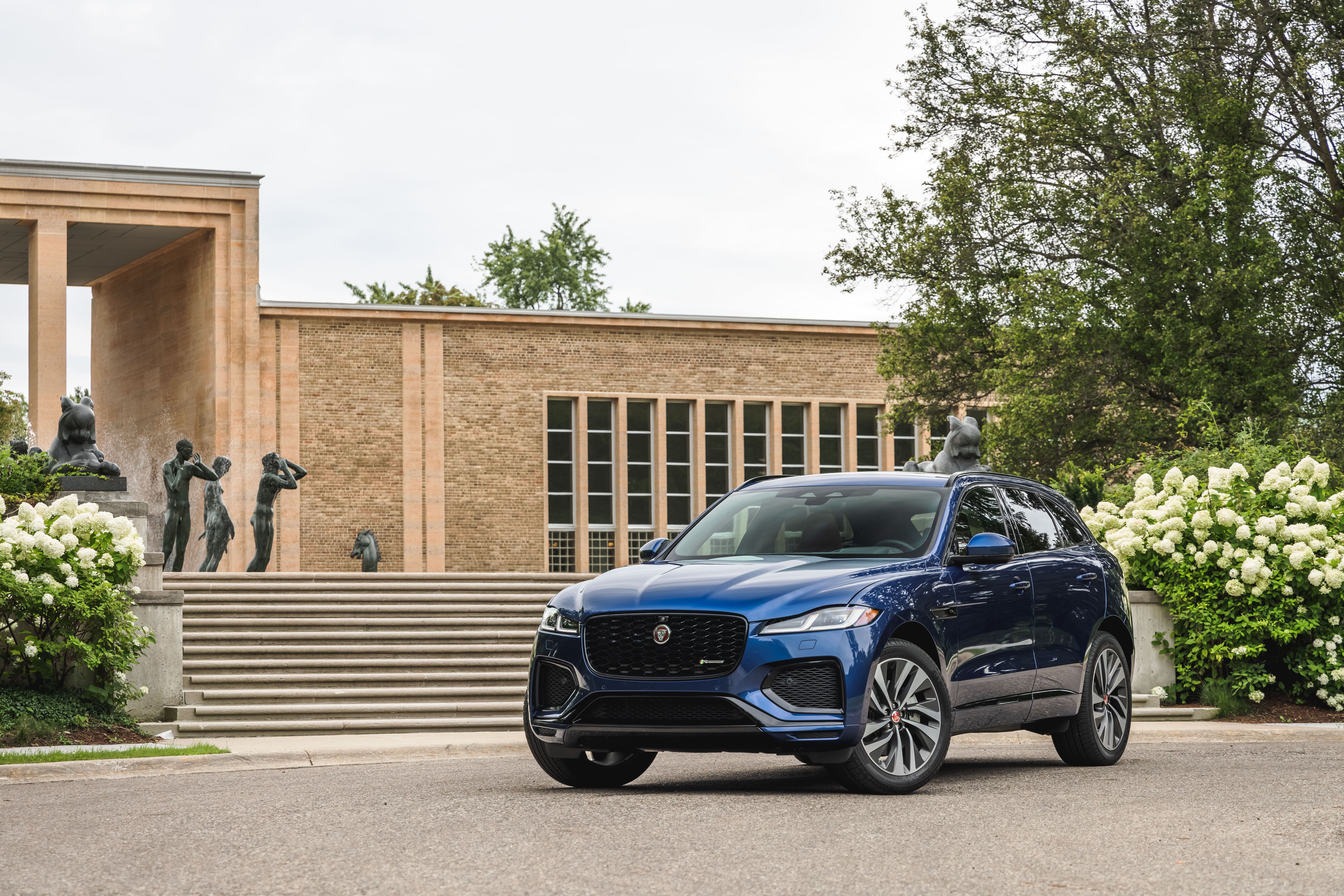 Blue Jaguar F-Pace SUV in front of a building HD Wallpaper
