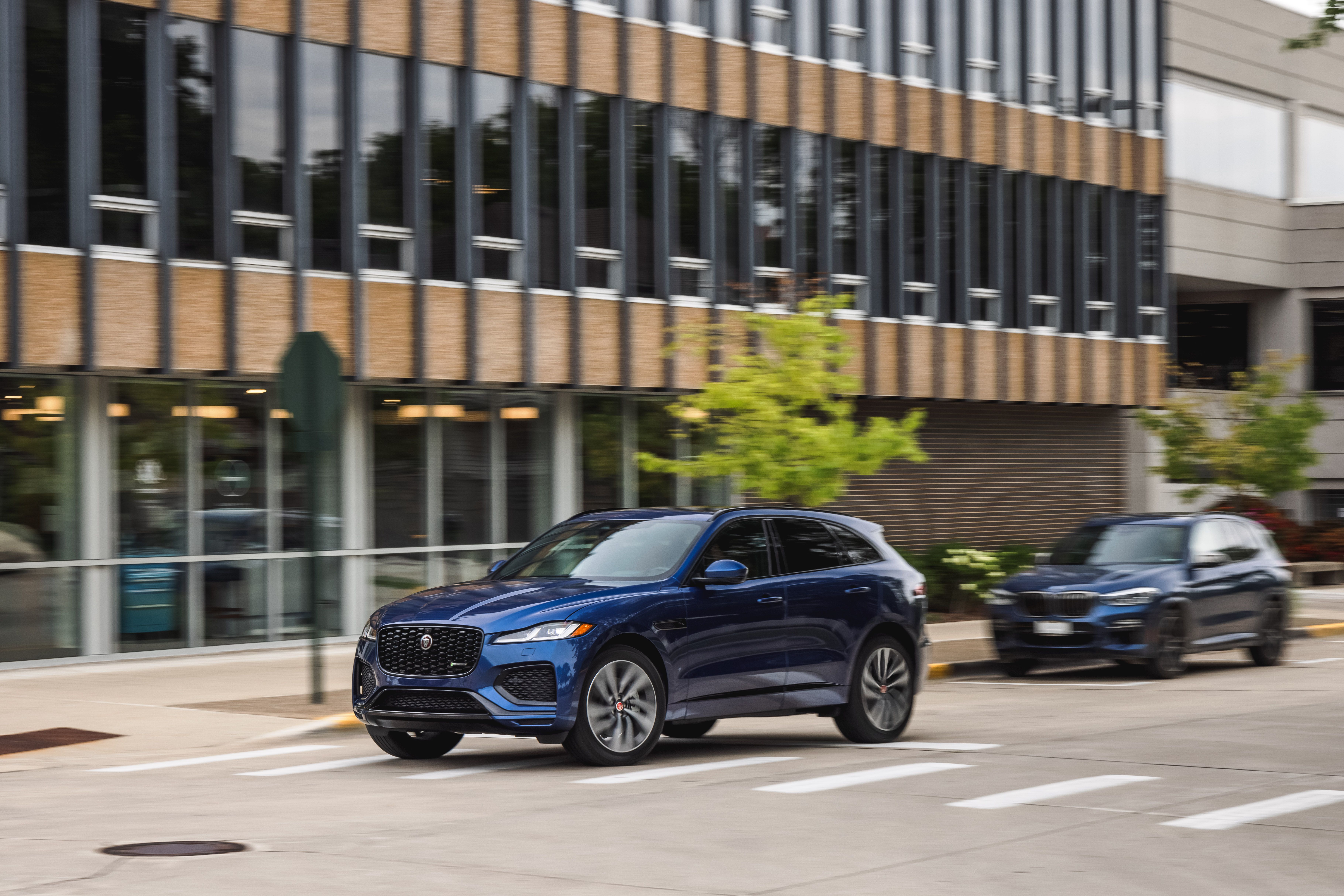 Blue Jaguar F-Pace P400 R-Dynamic SUV driving on street HD Wallpaper
